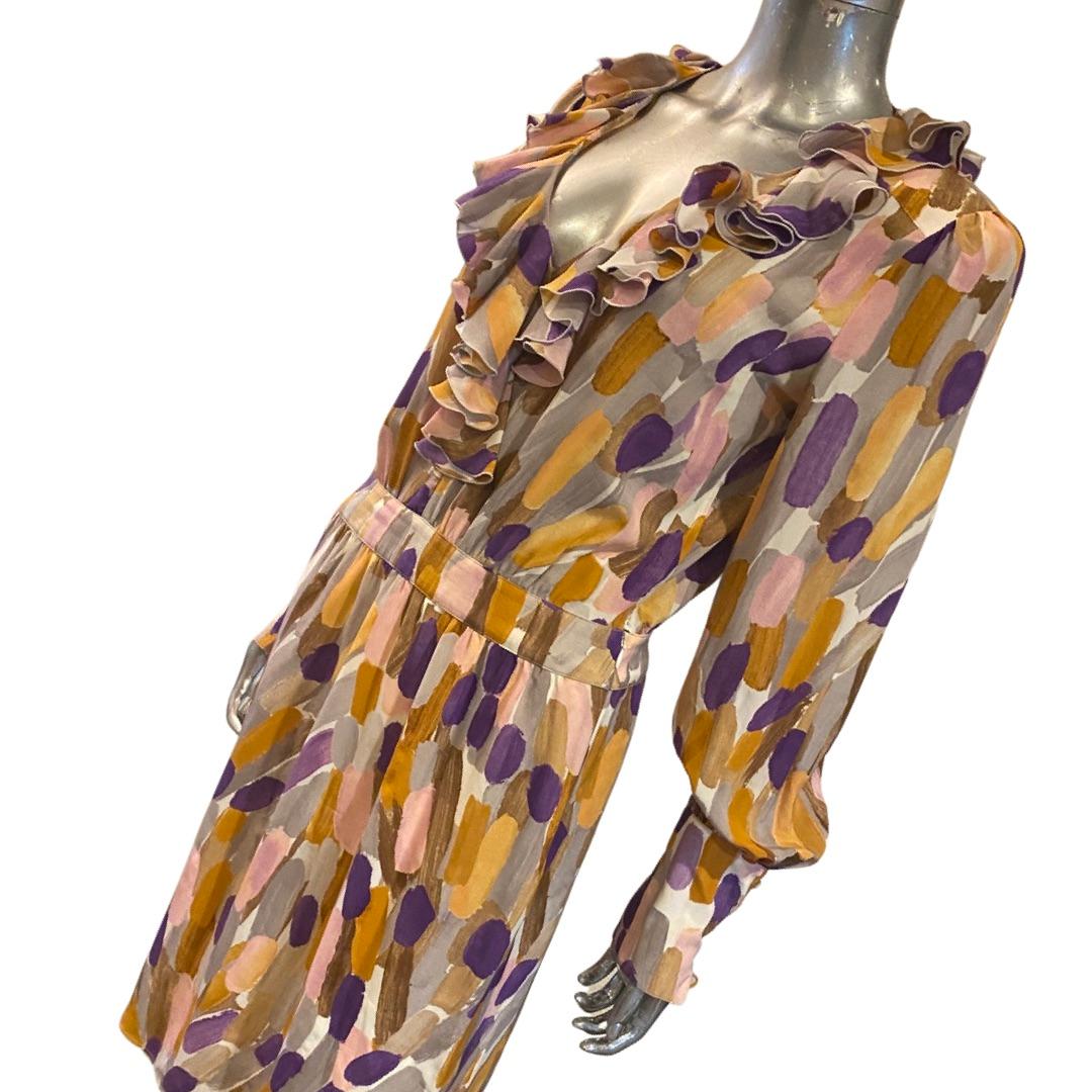 This is a beautiful vintage dress by Escada. Done in a hand-painted looking watercolor abstract silk. The dress has a beautiful ruffle design at the neck down to the waist line. Large Coffe design with six mother of pearl buttons to add volume to
