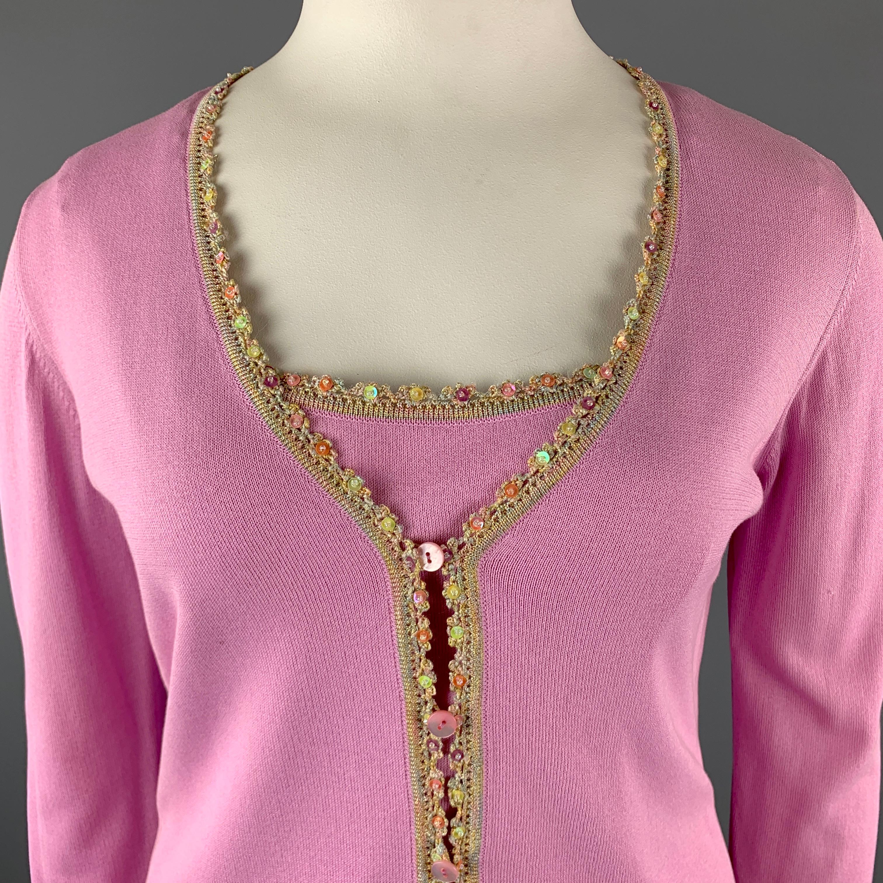ESCADA Cardigan Camisole Set comes in a pink tone in a solid rayon blend material, a contrast embellished trim, and includes a V-neck cardigan with faux slit pockets, and a matching tank top sleeveless camisole. Minor wear. 

Very Good Pre-Owned