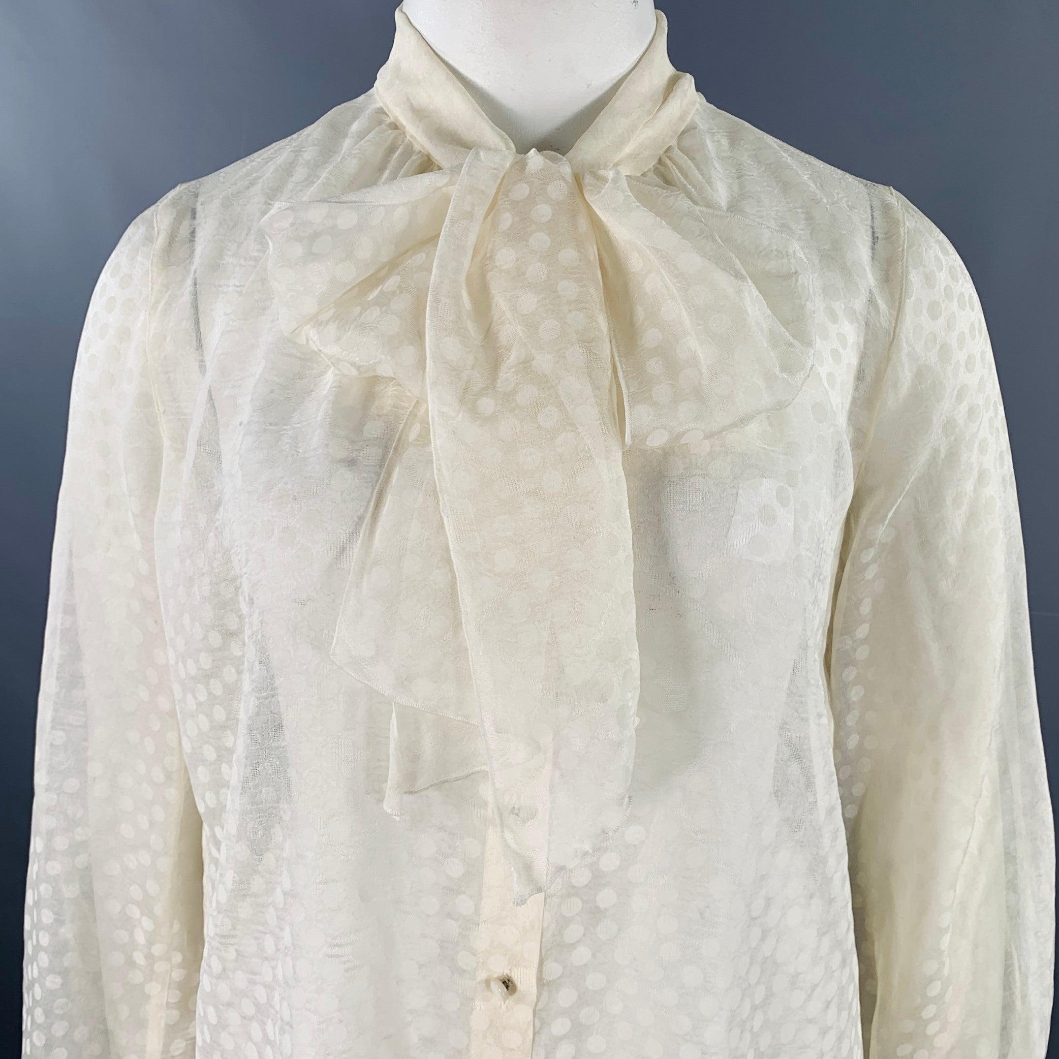 ESCADA blouse
in a beige silk featuring a sheer style with dots pattern, long sleeves, and button closure with pussybow tie.New with Tags. 

Marked:   FR 42 

Measurements: 
 
Shoulder: 14.5 inches Bust: 44 inches Sleeve: 26.5 inches Length: 25