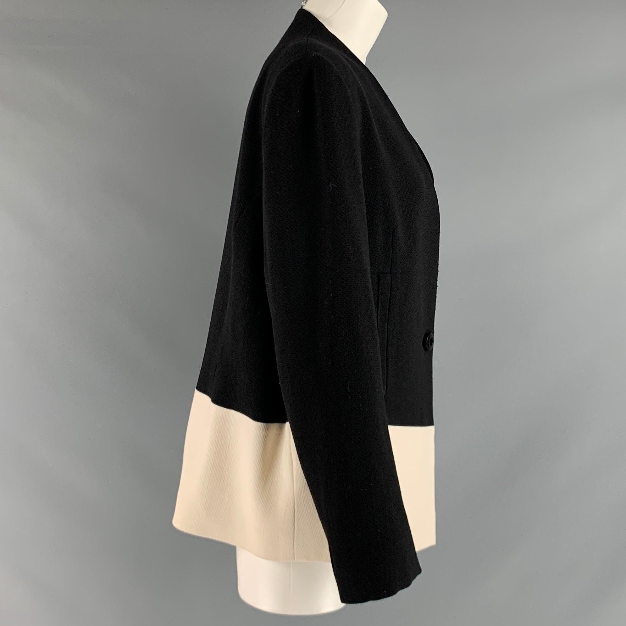 ESCADA blazer comes in black and cream wool blend knit material featuring a color block style, collarless design, and button closure.Very Good Pre-Owned Condition. Moderate signs of wear. 

Marked:   44 

Measurements: 
 
Shoulder: 17 inches Bust: