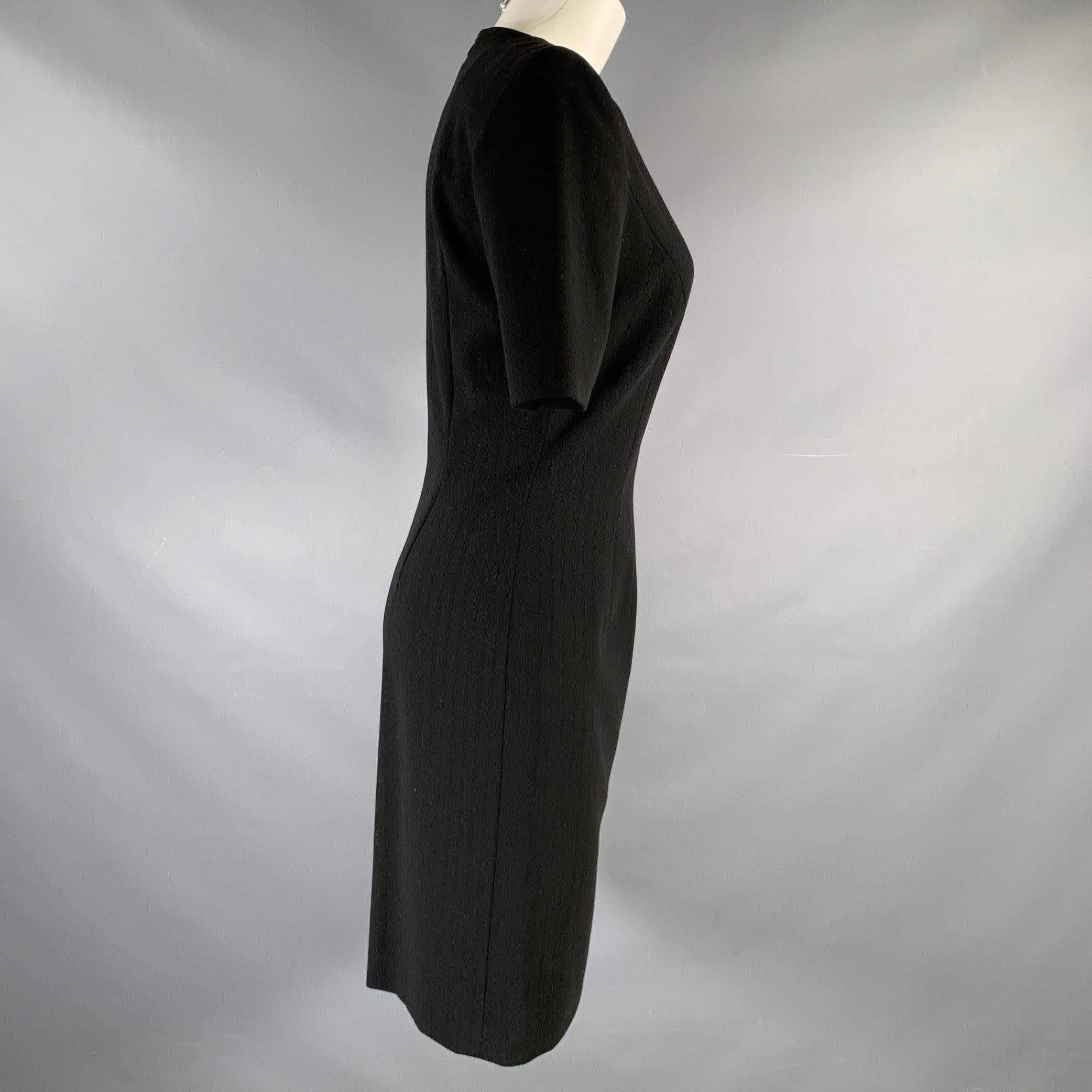 ESCADA Margaretha Ley cocktail dress
in a black virgin wool fabric featuring a short sleeve style, knee length, and back zipper closure.Excellent Pre-Owned Condition. 

Marked:   34 

Measurements: 
 
Shoulder: 15 inches Sleeve: 11 inches Bust: 34