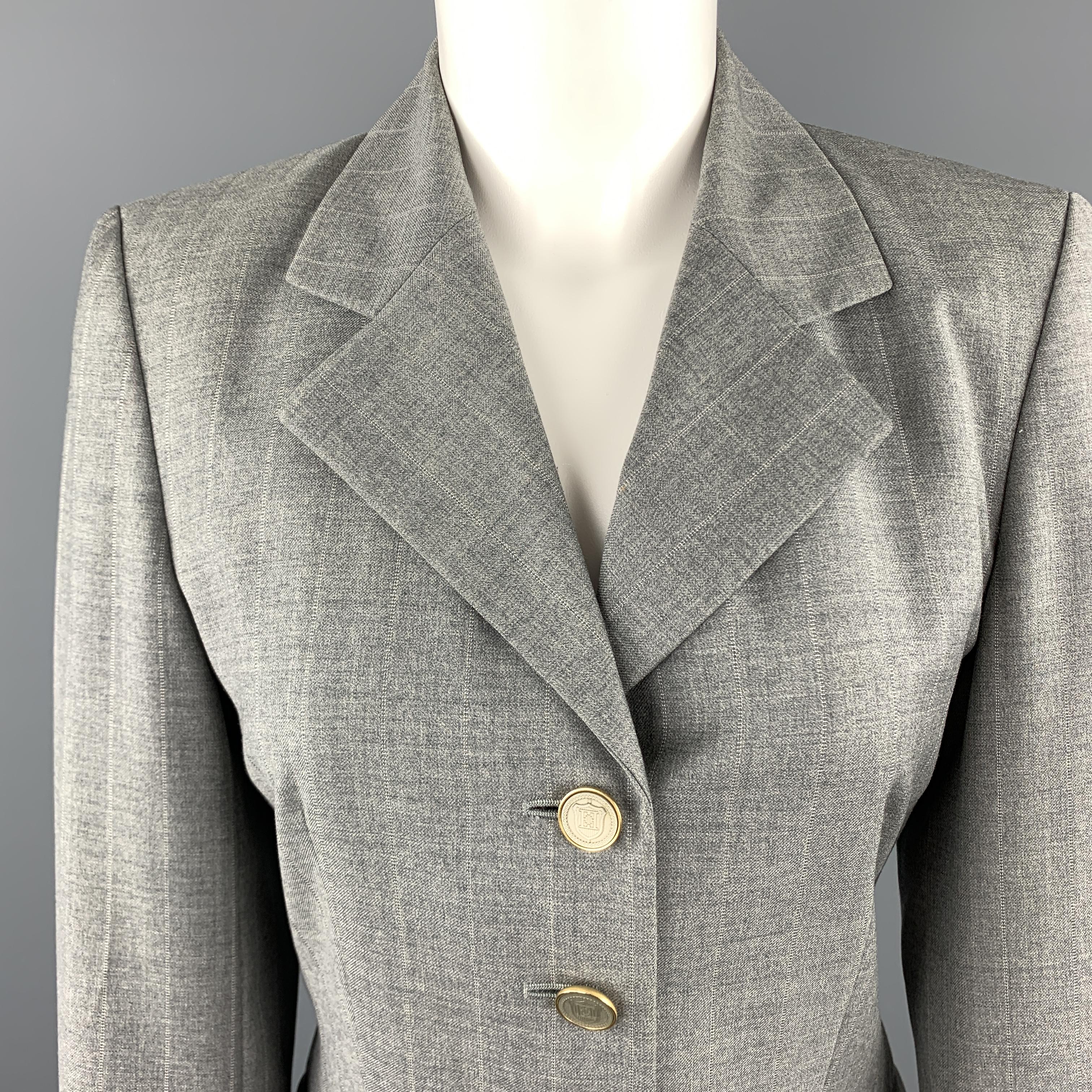 ESCADA jacket comes in grau plaid Ermenegildo Zegna Certified Australian virgin wool with a pointed lapel, single button front, and button detailed cuffs with gold tone metal enamel crest buttons throughout. Made in Germany.

Excellent Pre-Owned