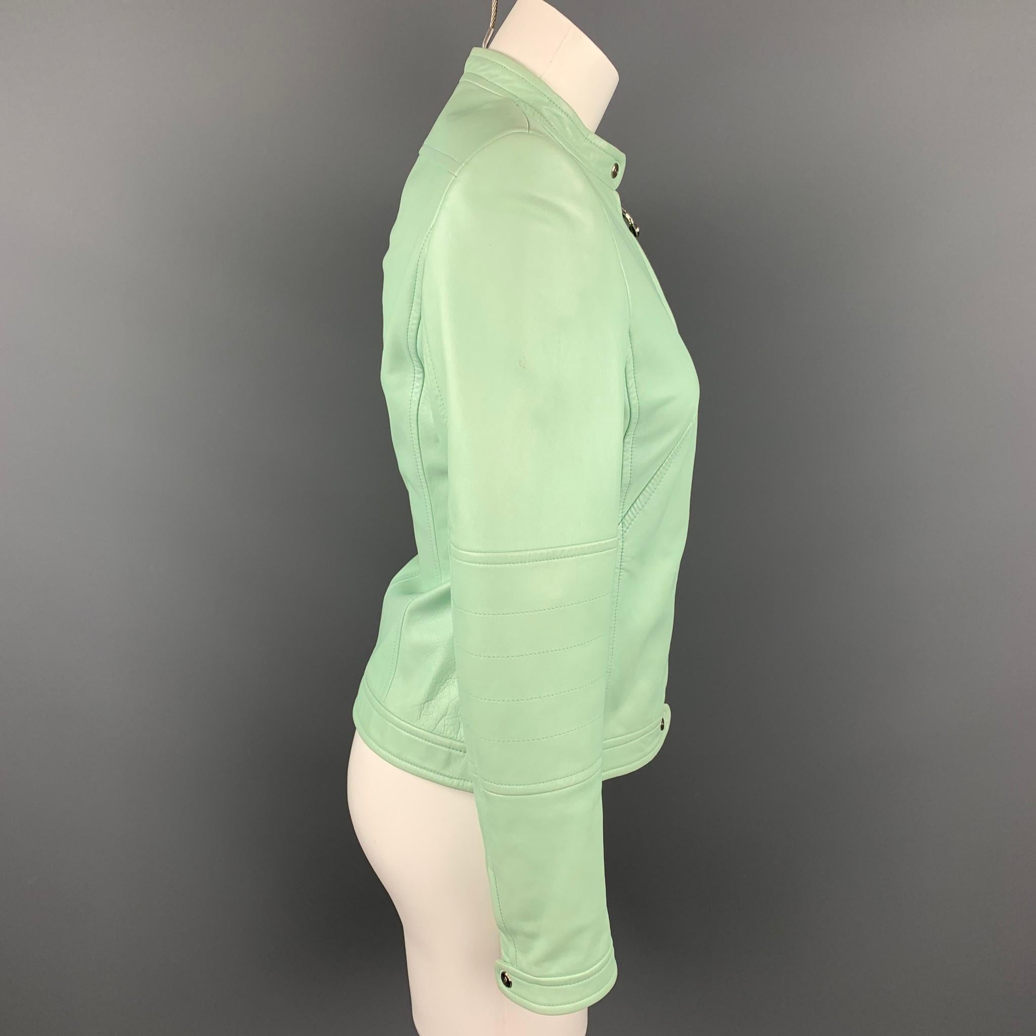 ESCADA jacket comes in a mint leather with a monogram print liner featuring a motorcycle style and a zip up closure. Moderate wear.

Very Good Pre-Owned Condition.
Marked: 34

Measurements:

Shoulder: 15 in.
Bust: 34 in.
Sleeve: 24 in.
Length: 21