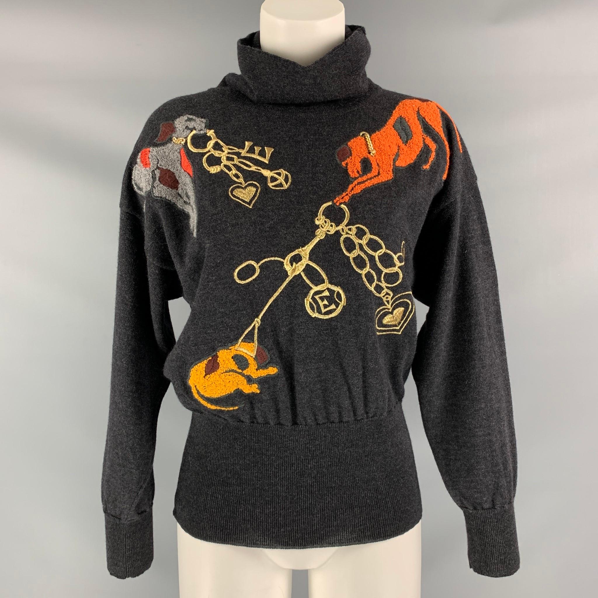 ESCADA drop shoulder turtleneck pullover comes in charcoal wool and features a gold tone chain with gray, orange and yellow dogs embroidered at front. Made in Italy.

Very Good Pre-Owned Condition. Minor hole has been fixed, approximately 1 cm at