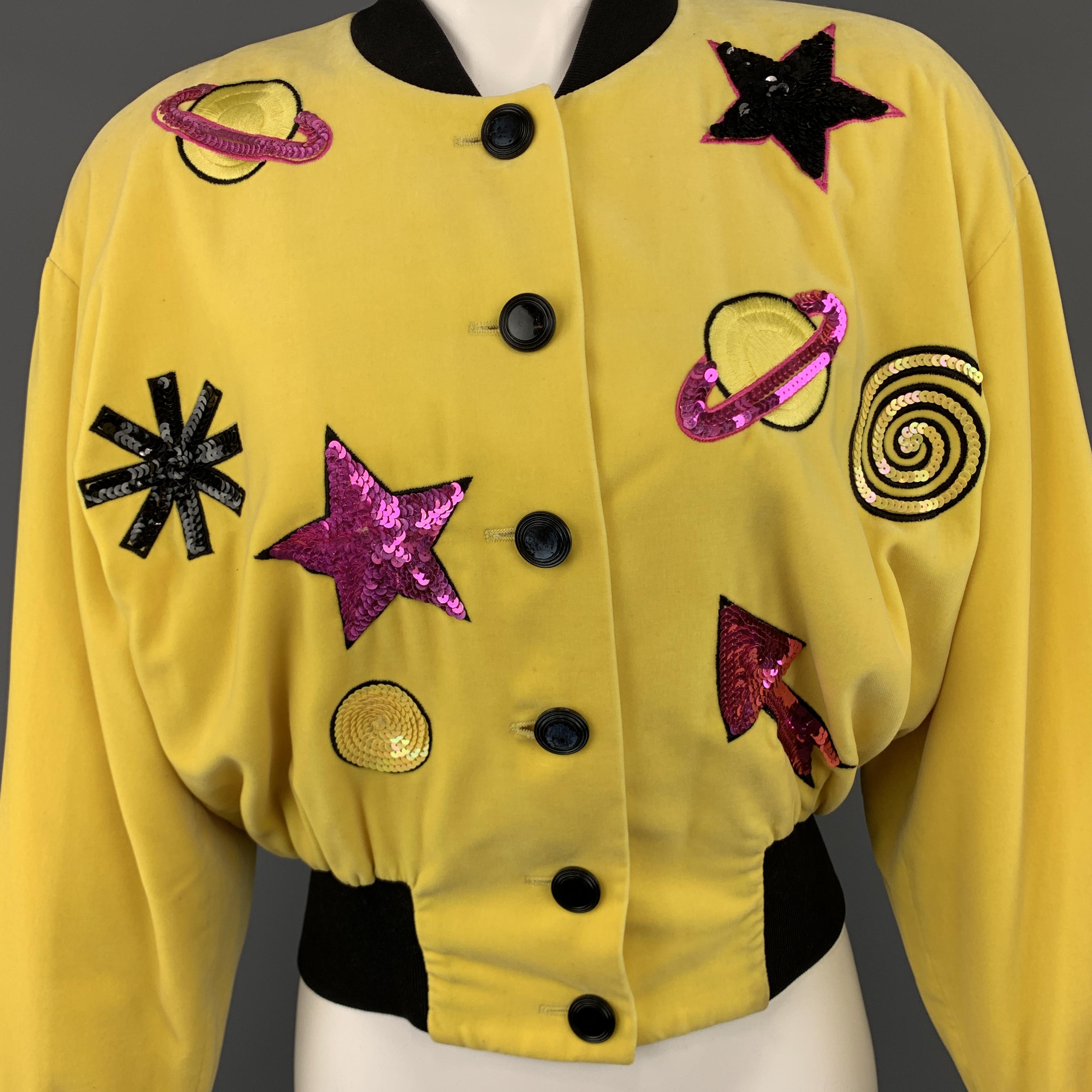 Vintage ESCADA bomber jacket comes in yellow velvet with a black baseball collar and waistband, pink sequined saturn, star, and arrow patches, and embroidered 