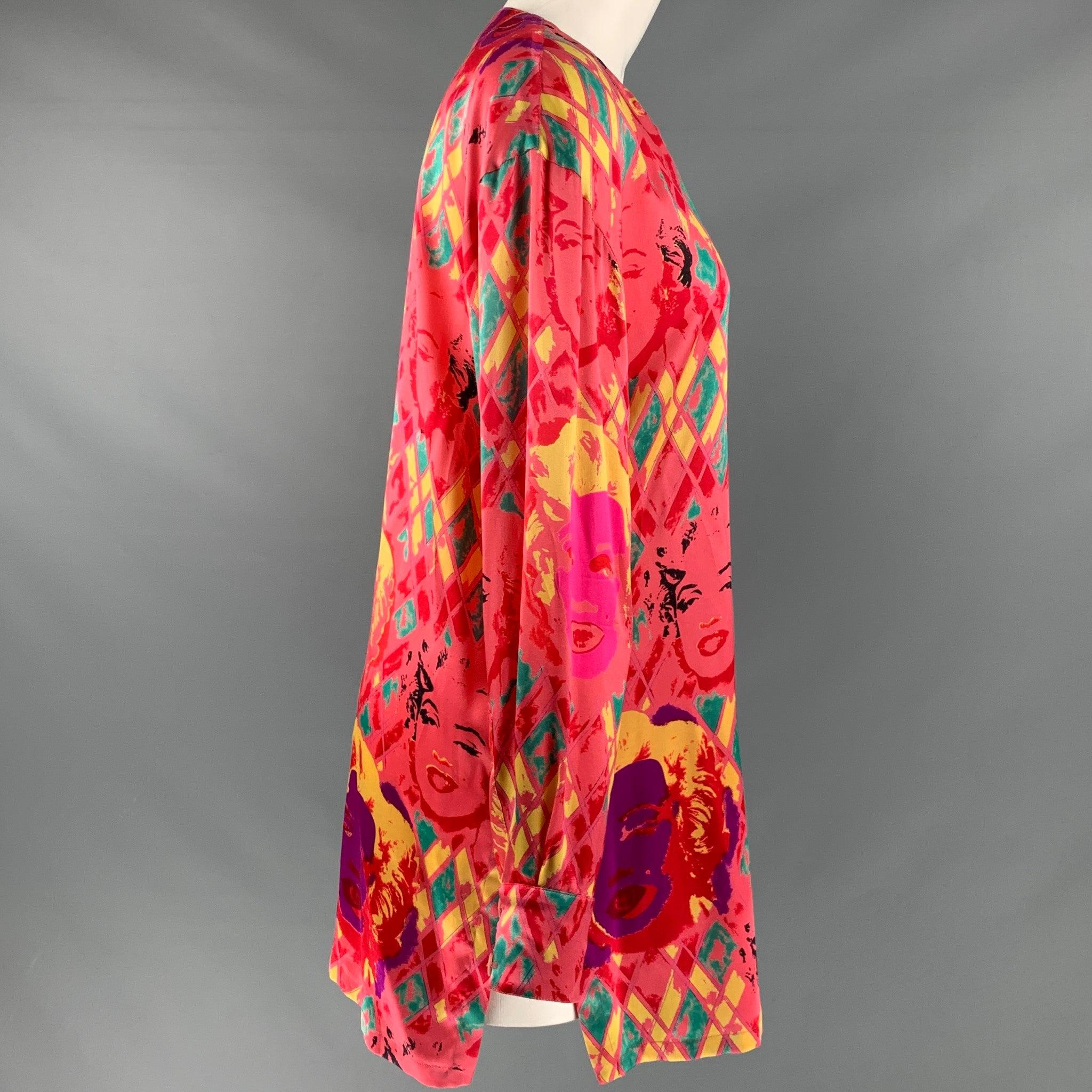 Camiseta ESCADA
en un tejido de seda rosa con un vibrante estampado multicolor de Marilyn Monroe y diamantes, estilo sin cuello y cierre de botones. Made in Germany. Muy buen estado de conservación. Pequeña marca en el cuello y falta un botón del