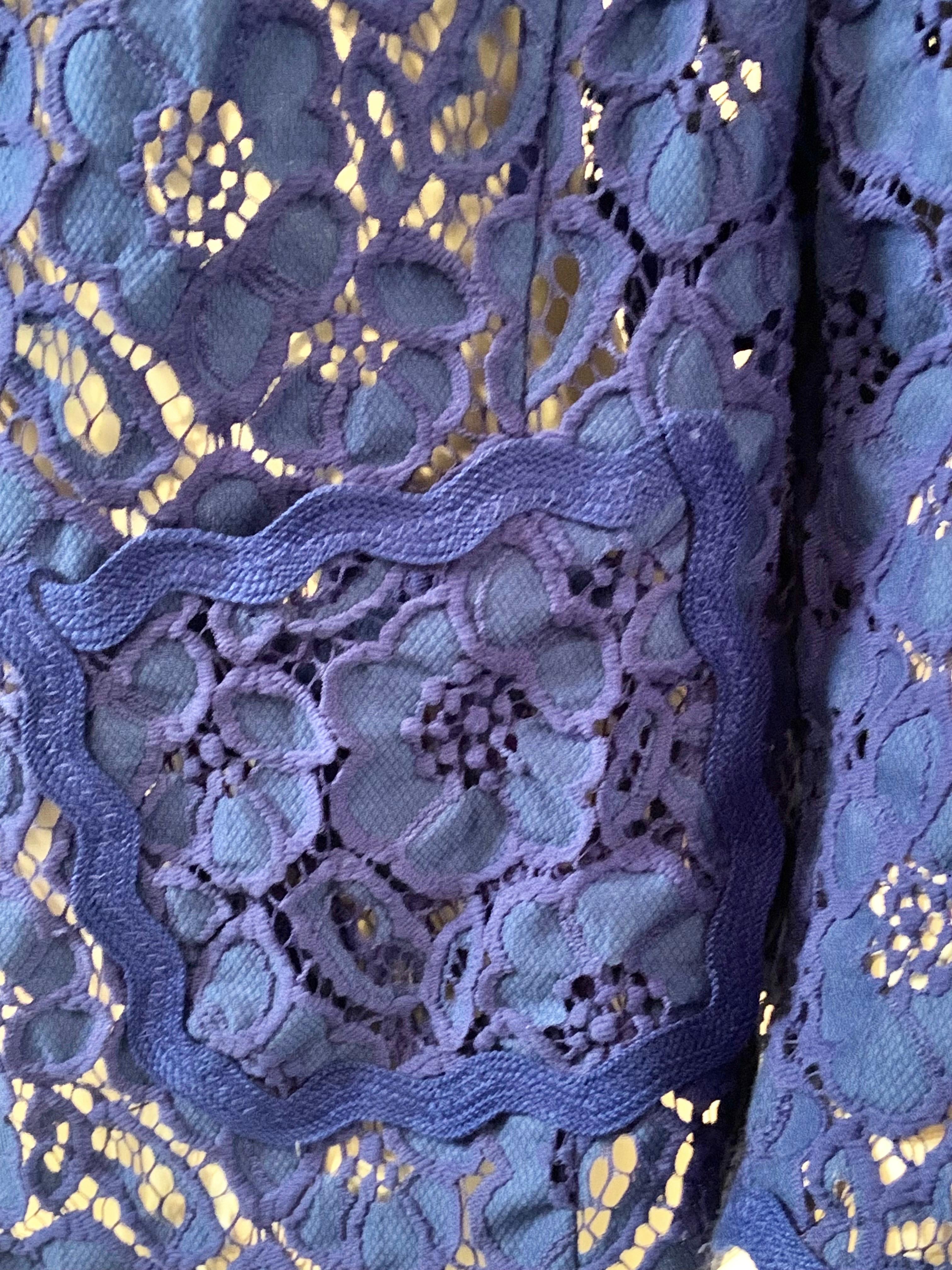 This unlined blue lace jacket from Margaretha Ley at Escada is perfect for Spring or Summer.  The jacket has peaked lapels, a single gold toned button and two patch pockets.  All of the edges are finished with a scalloped blue braid.  the jacket is