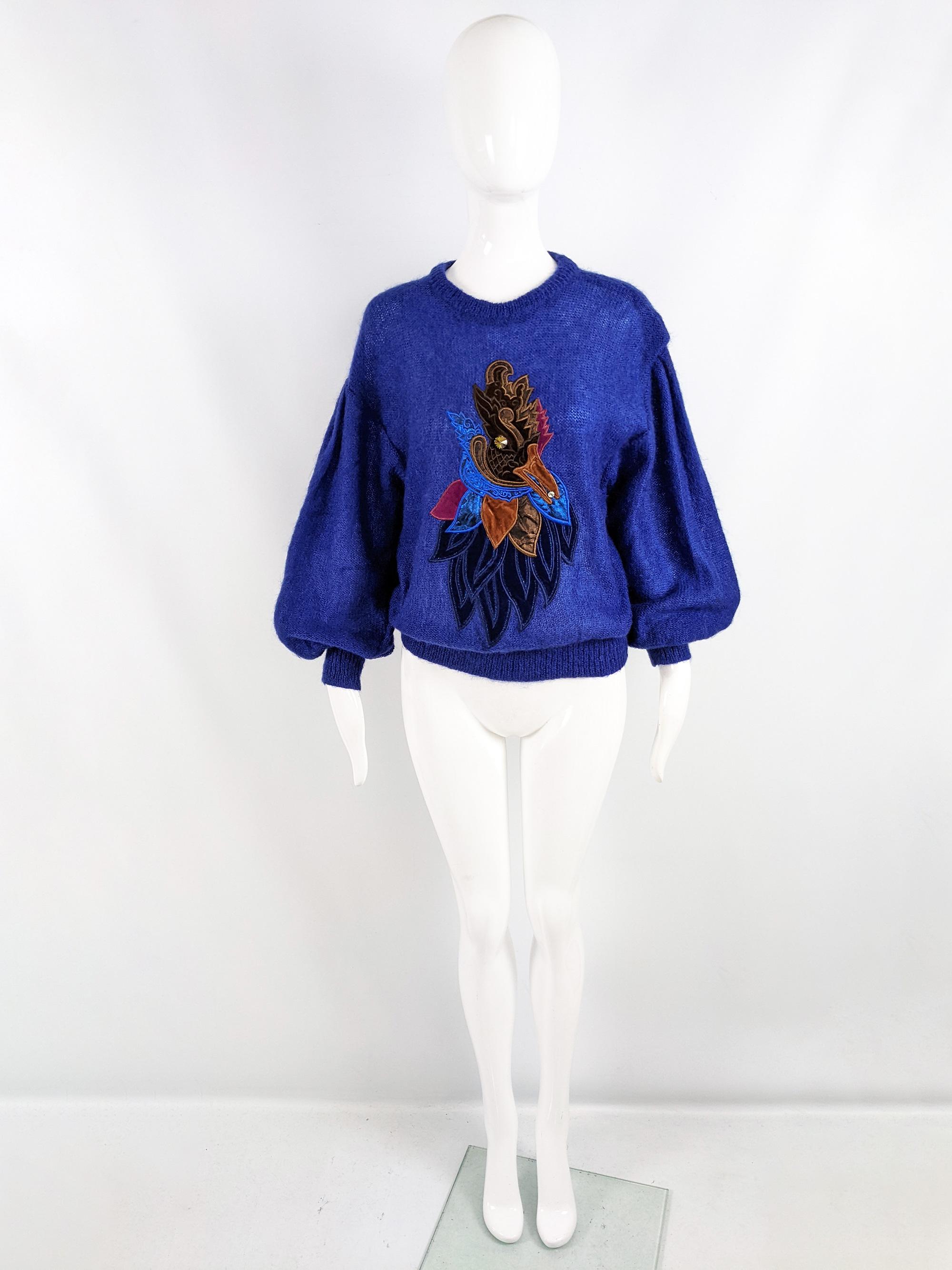 A fabulous vintage womens sweater from the 80s by luxury fashion house, Escada. In a dark blue mohair blend soft, fuzzy knit fabric. It has huge puffed sleeves with dropped shoulder seams and a bold rooster design in embroidered velvet appliqués on