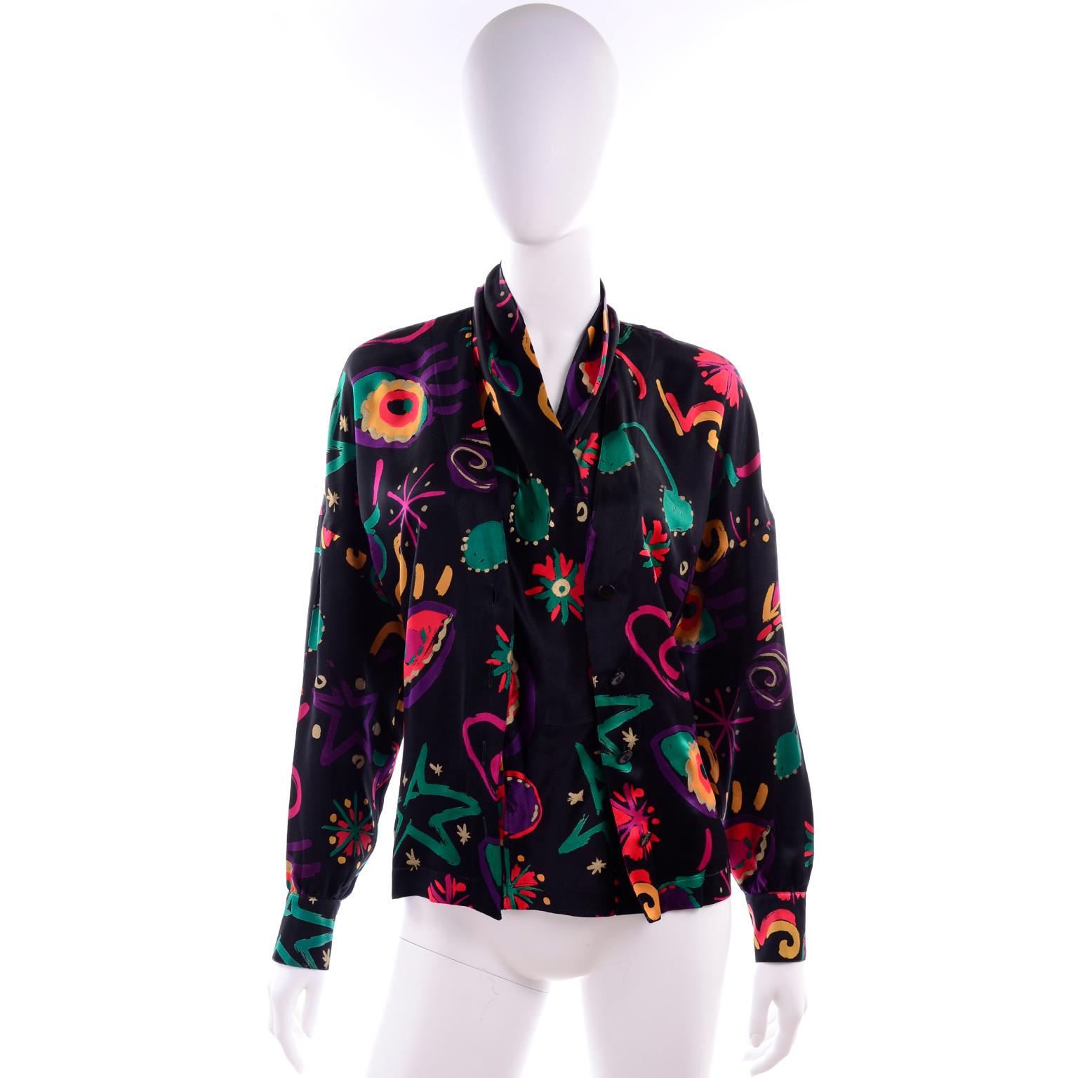 We love Escada blouses and this one is really incredible. This was designed by Margaretha Ley in the 1980's. The blouse is in an abstract print silk and has black buttons down the front. This top is in excellent condition and is labeled a size 38.