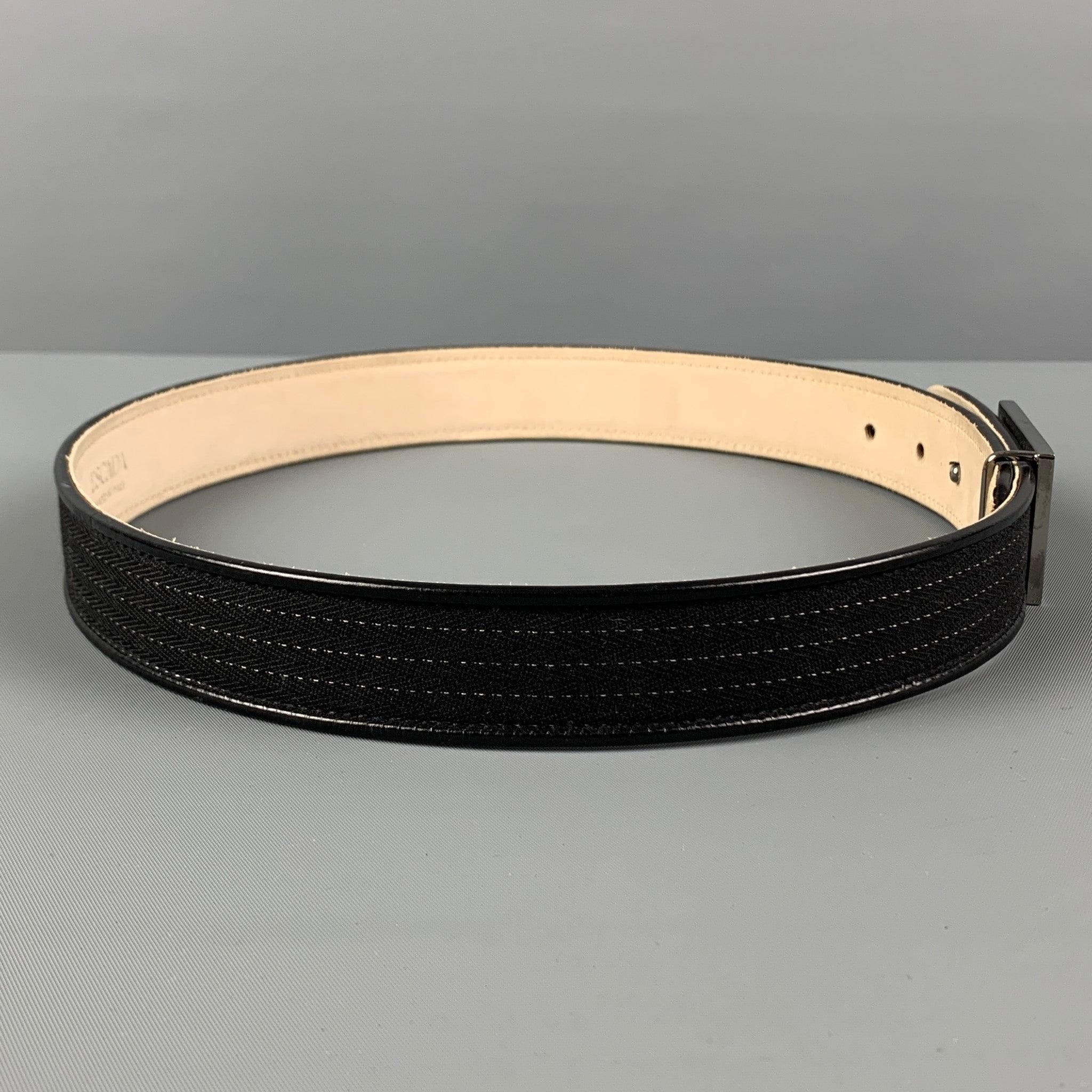 ESCADA belt comes in a black material with a leather trim featuring a buckle closure. Made in Italy.
 Very Good
 Pre-Owned Condition. 
 

 Marked:  52488-6902 34Length: 32 inches Width: 1 inches Fits: 27 inches - 29 inches Buckle: 2 inches 
  
  
 