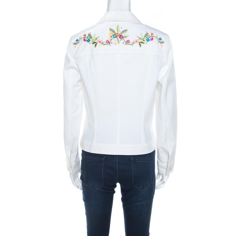 This lovely jacket is designed by Escada from a cotton blend. It features a multicolor floral embroidery at the front and back, near the shoulders. Designed with long sleeves, the white denim creation comes with chest pockets and buttoned closure.
