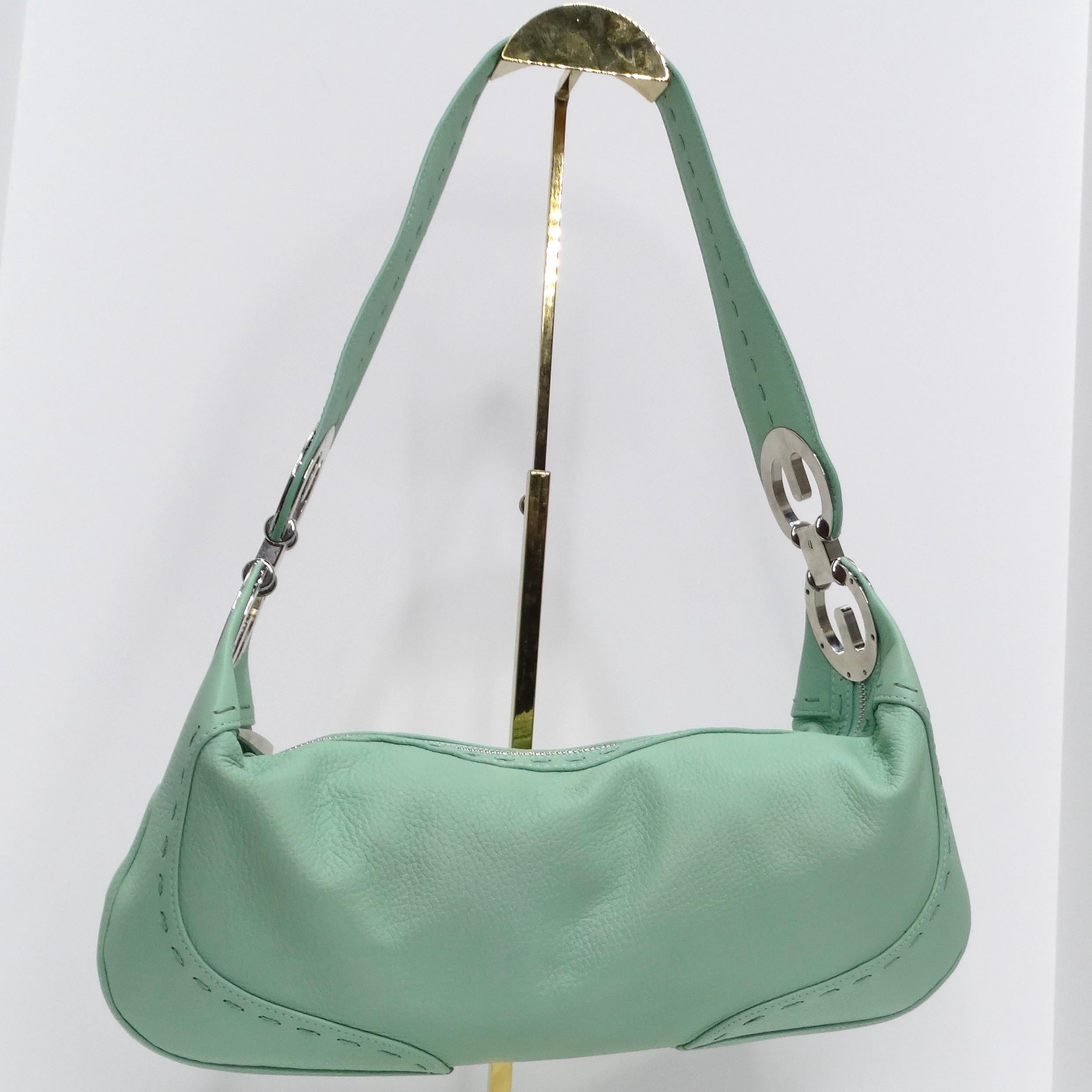 Introducing the Escada 1990s Eluna Mint Blue Leather Hobo Shoulder Bag - a masterpiece in vibrant elegance! This stunning hobo bag boasts the most beautiful mint blue leather, complemented by silver-tone accents featuring iconic Escada logos.