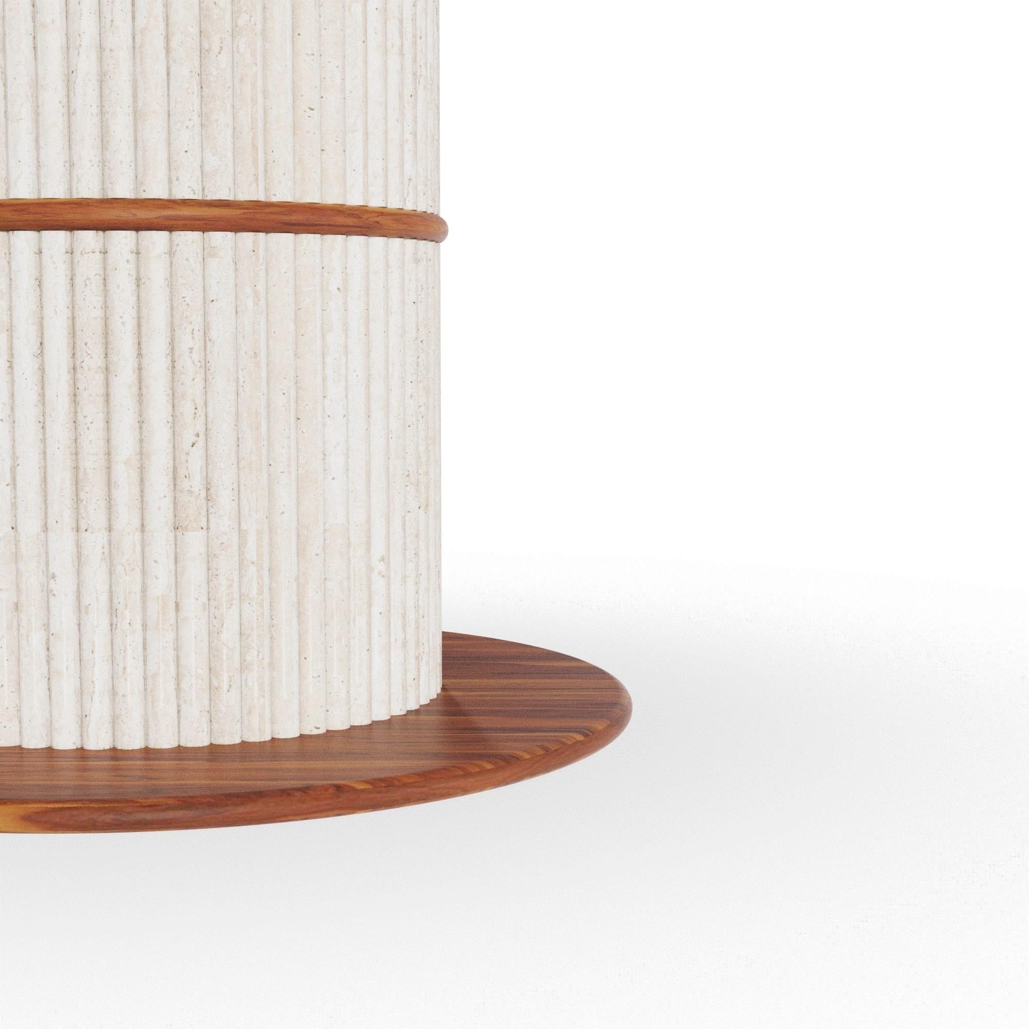 Il tavolo da pranzo rotondo Escalet, creato in collaborazione con Mediterrazza, incarna l'eleganza mediterranea attraverso materiali nobili e naturali. Realizzato a mano in legno di iroko, presenta una base scultorea in travertino a coste abbinata a