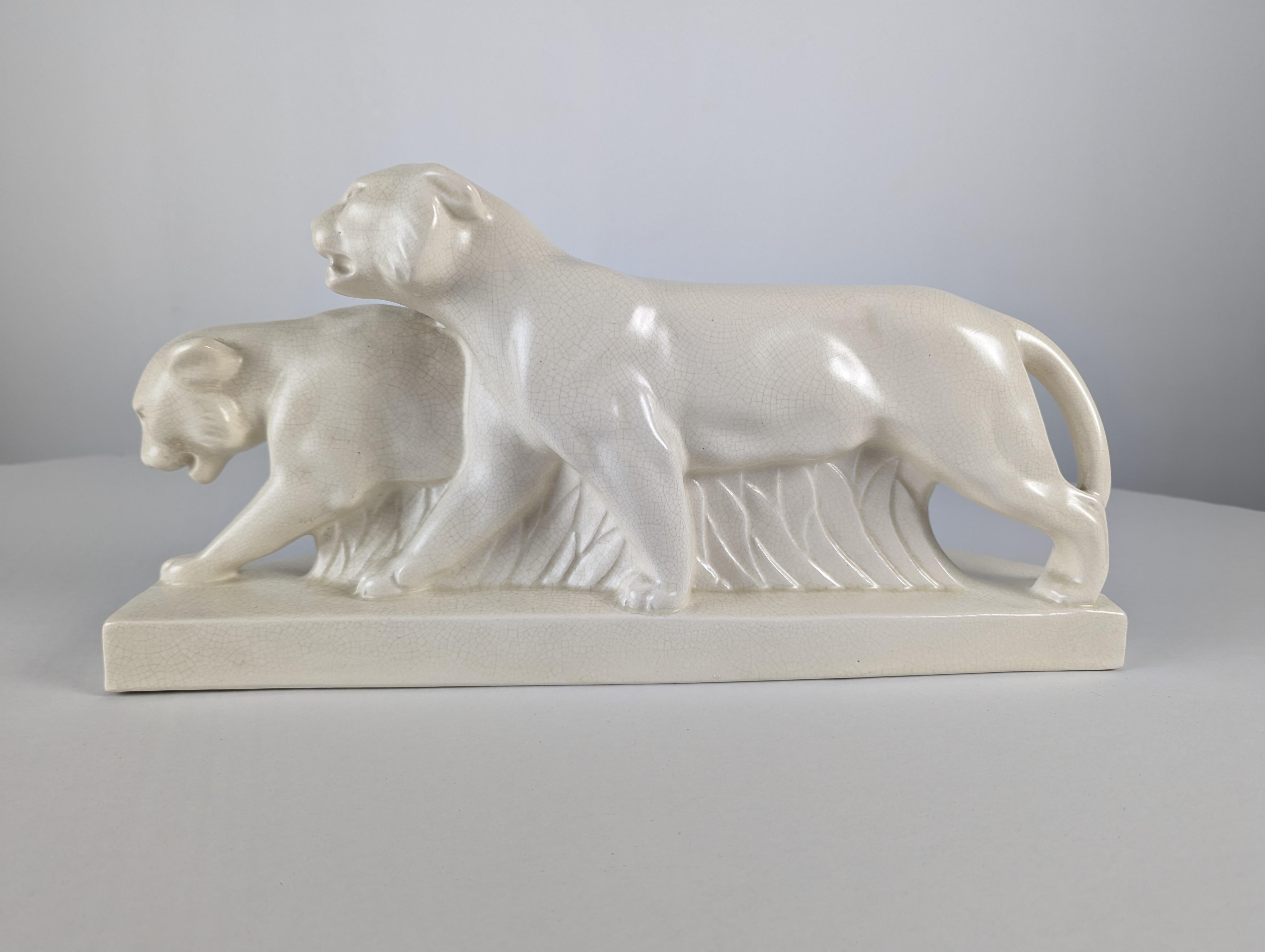 Spectacular piece of cracked ceramic that captures the essence of the Art Deco period. This stunning work of art features two stylized lionesses in full motion, evoking the grace and elegance characteristic of the era. The crackle effect on the