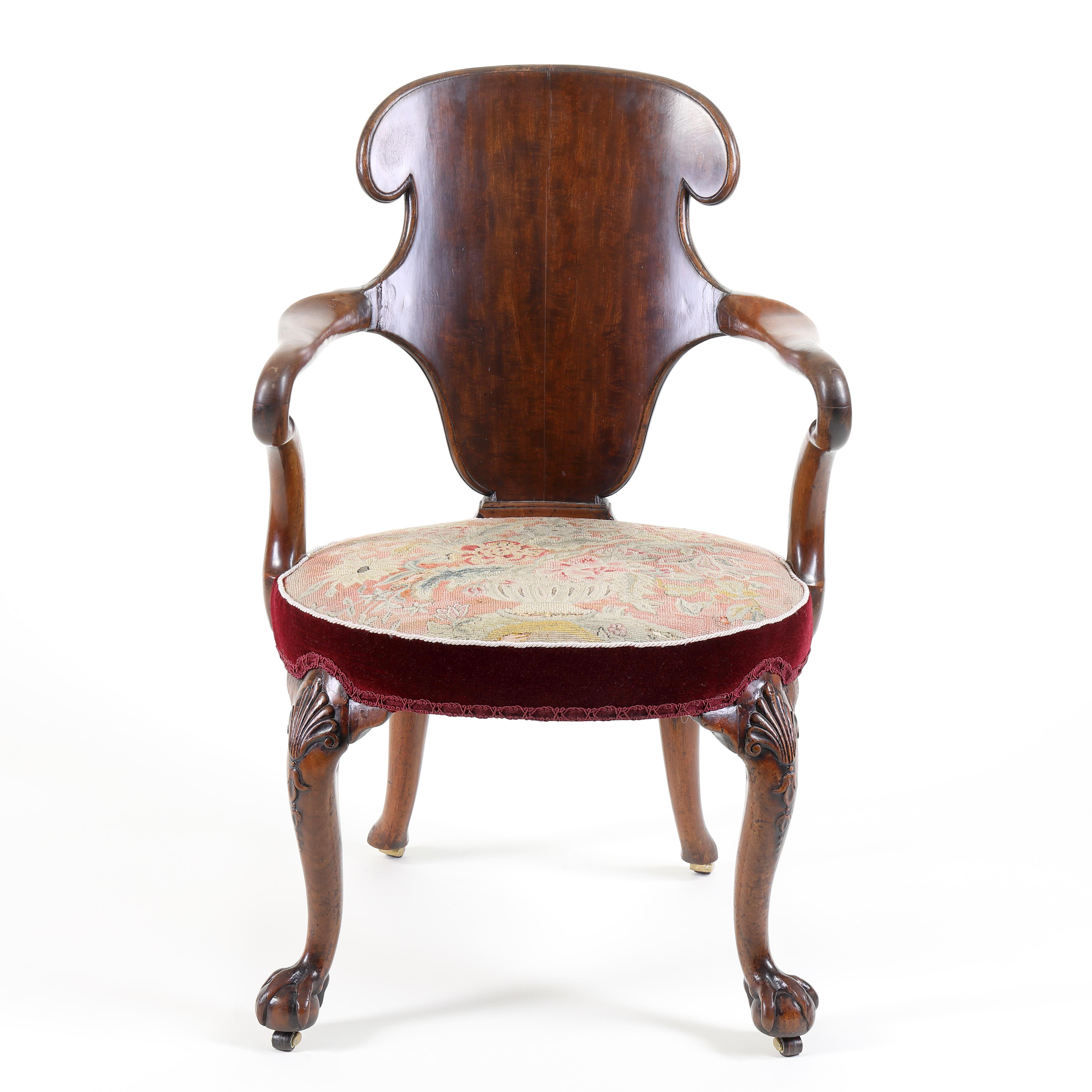 A exceptional and very rare George I period ‘escutcheon-back’ walnut armchair with mahogany back. The well-shaped and curved mahogany back above a circular seat retaining the ORIGINAL TAPESTRY cover, with two scrolled and out-swept arms. Standing on