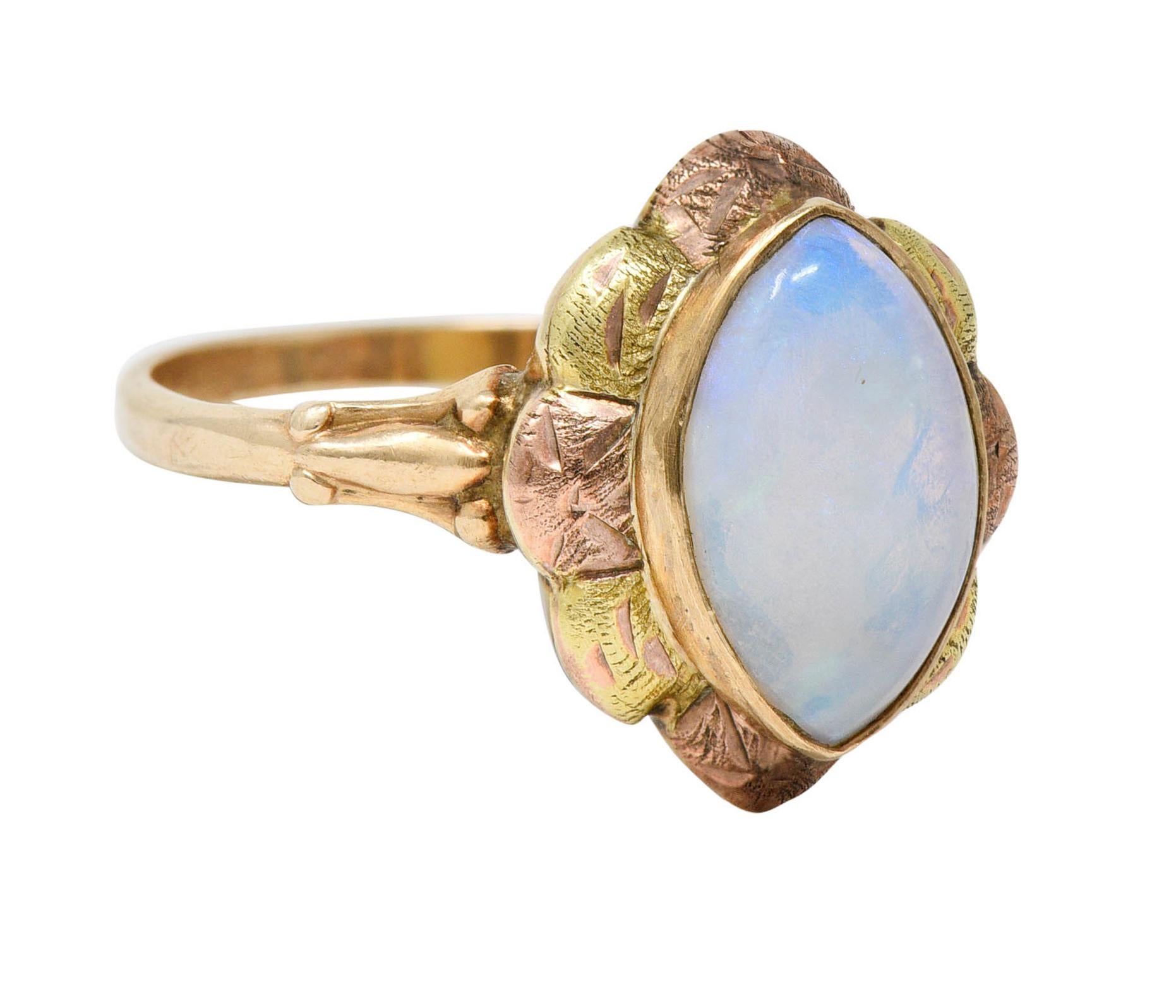 Centering a navette opal cabochon measuring approximately 12.0 x 7.0 mm

Opal is translucent white in body color with moderate green/blue play-of-color

With floral green and rose gold surround

Completed by grooved shoulders and slim band

Stamped