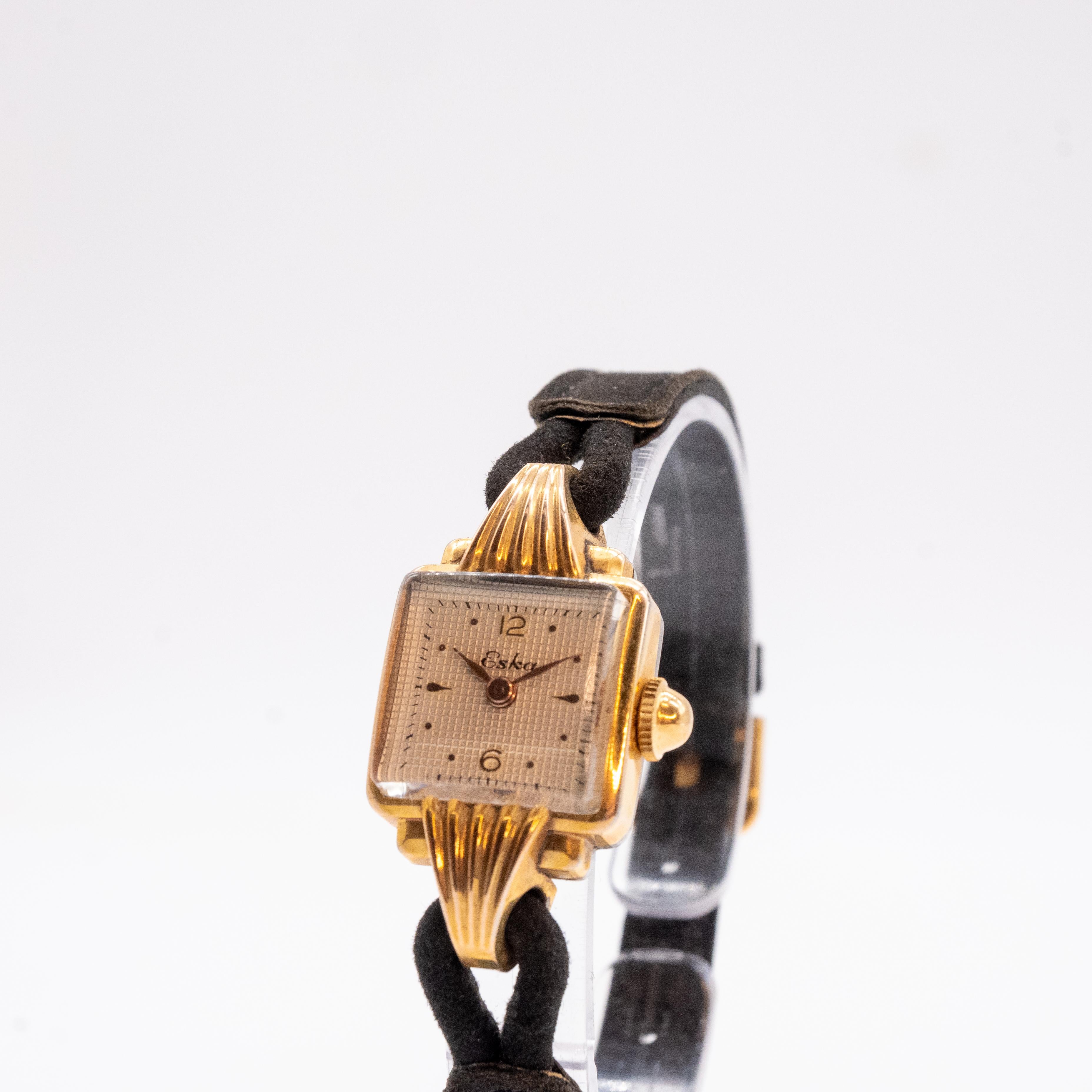 Entdecken Sie unsere Uhr Eska mit ihrem vergoldeten 20-Mikron-Gehäuse. Die gelbe Muschelverzierung auf den Bandanstößen verleiht diesem Modell einen femininen Touch. Mit ihrem quadratischen Design von 17 mm verkörpert diese Uhr Raffinesse in all