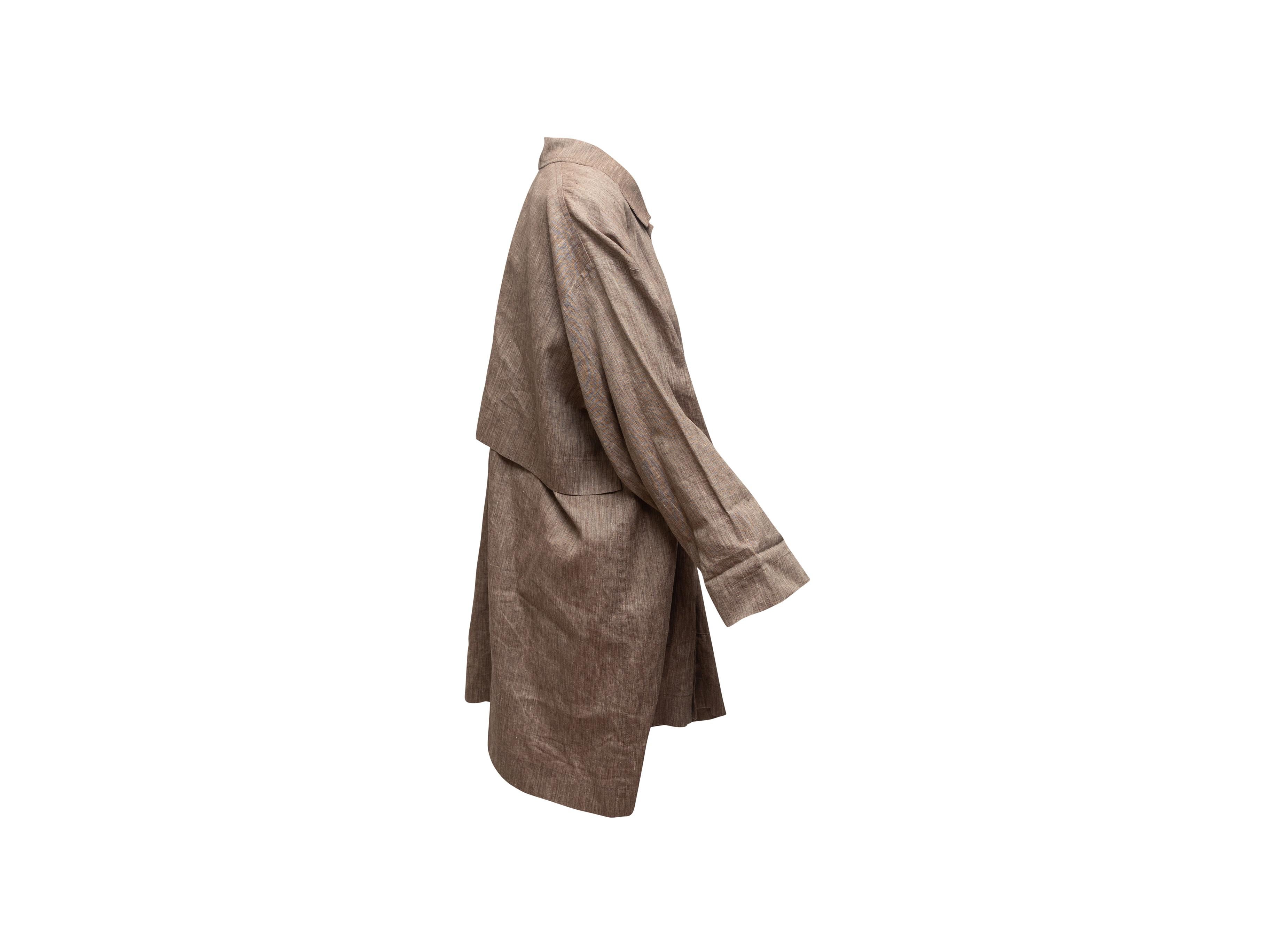 Product details: Light brown linen oversized coat by Eskandar. Pointed collar. Dual flap pockets at hips. Button closures at center front. 54