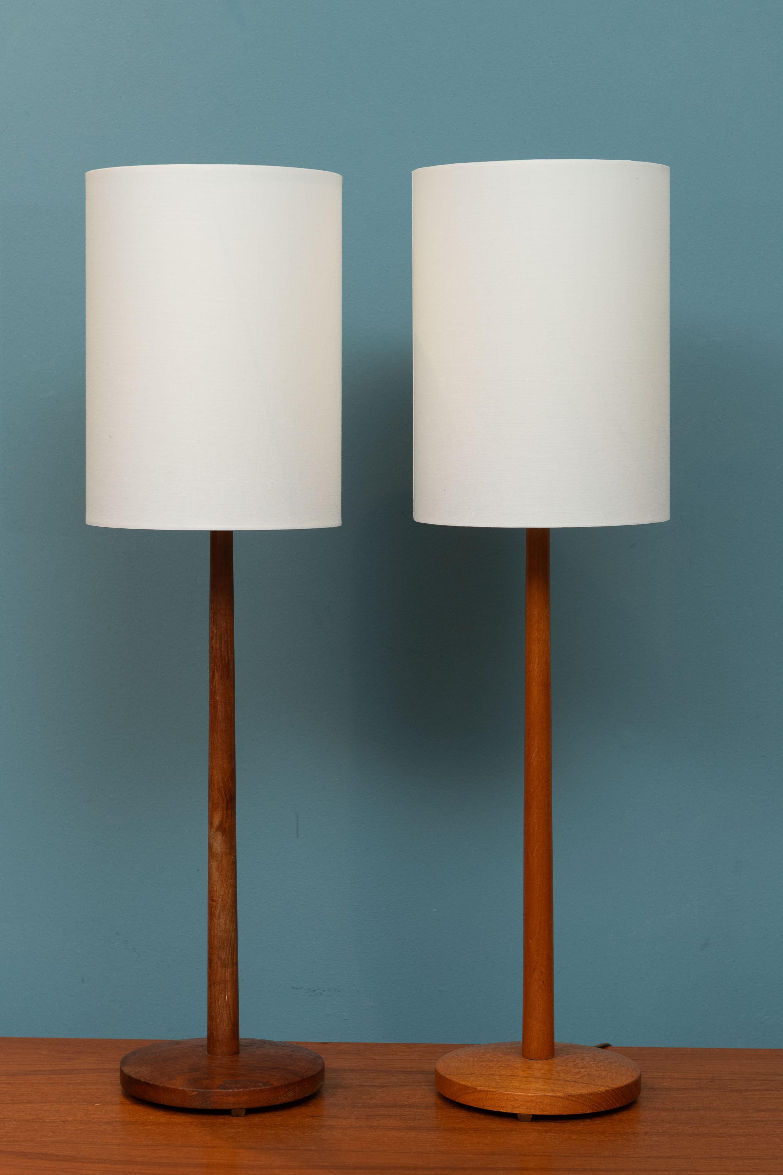 Pair of simple yet elegant design teak table lamps attributed to Eskilstuna Armatur, Sweden. The lamps are a associated pair and have a slight color difference but does include the new shades if desired.
