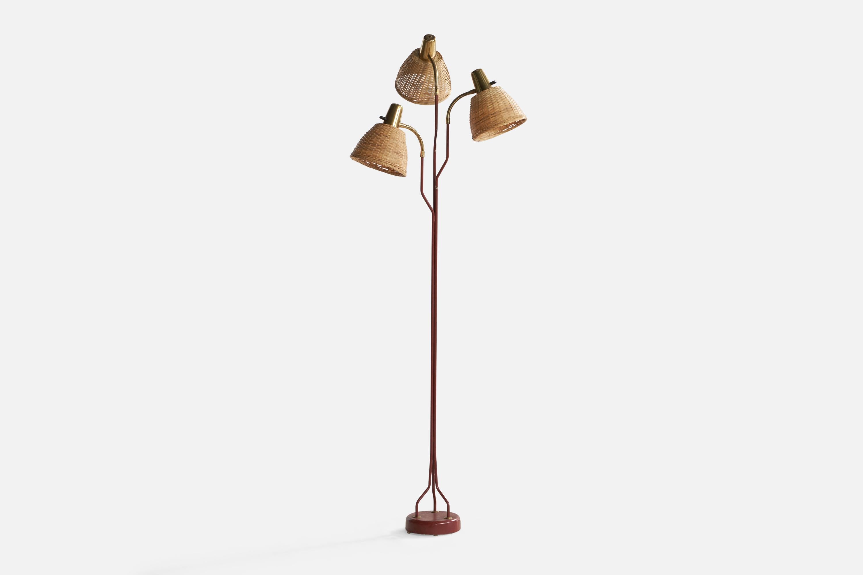 An adjustable three-armed brass, red-lacquered metal and rattan floor lamp, designed and produced by Eskilstuna Elektrofabrik Aktiebolag, Sweden, c. 1960s.

Overall Dimensions (inches): 61.75” H x 21” W x 19” D. Stated dimensions include