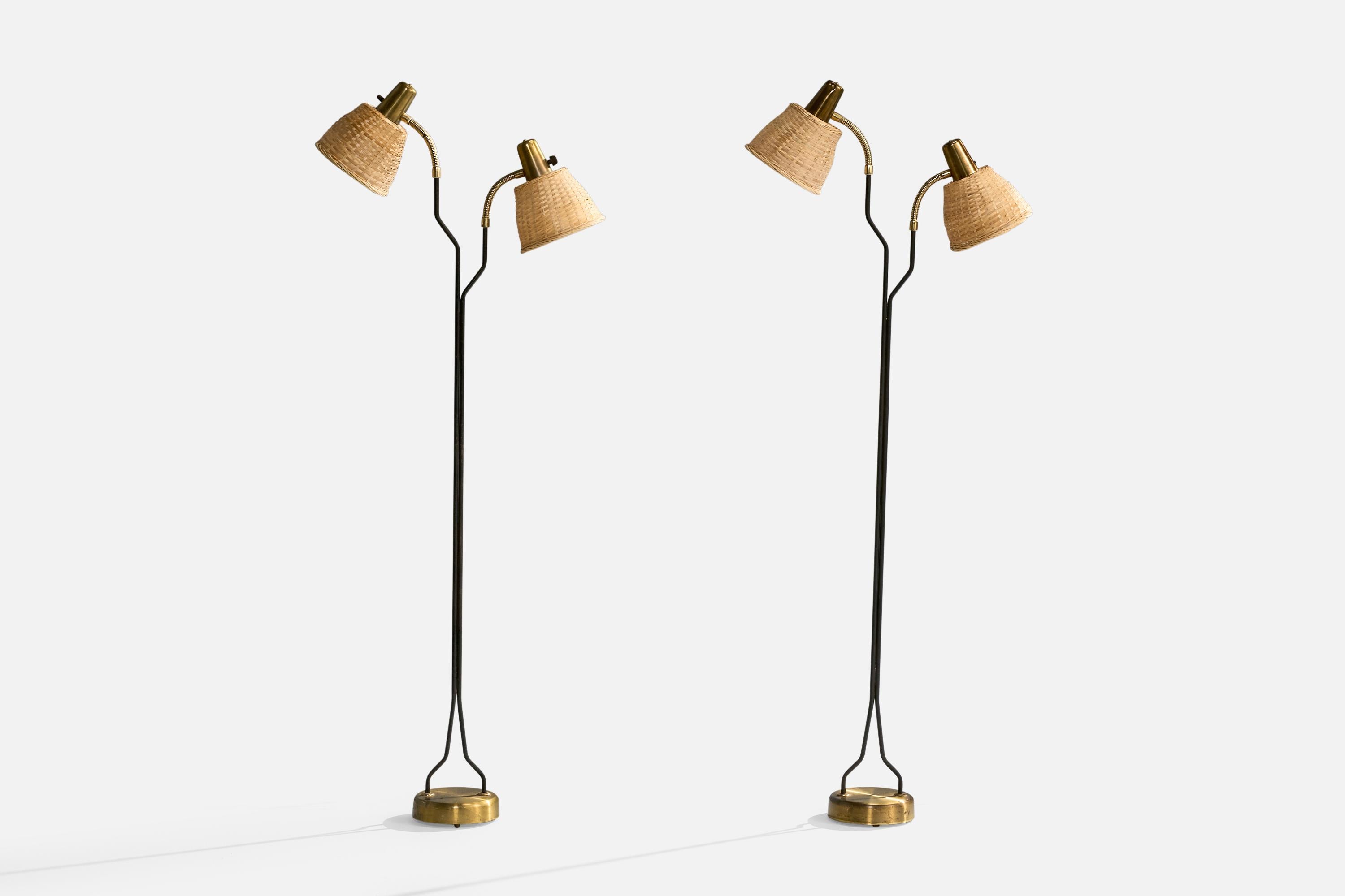 A pair of adjustable two-armed brass, black-lacquered metal and rattan floor lamps designed and produced by Eskilstuna Elektrofabrik Aktiebolag, Sweden, c. 1960s.

The brass base presents with heavy oxidation. Replaced rattan lampshades.

Dimensions