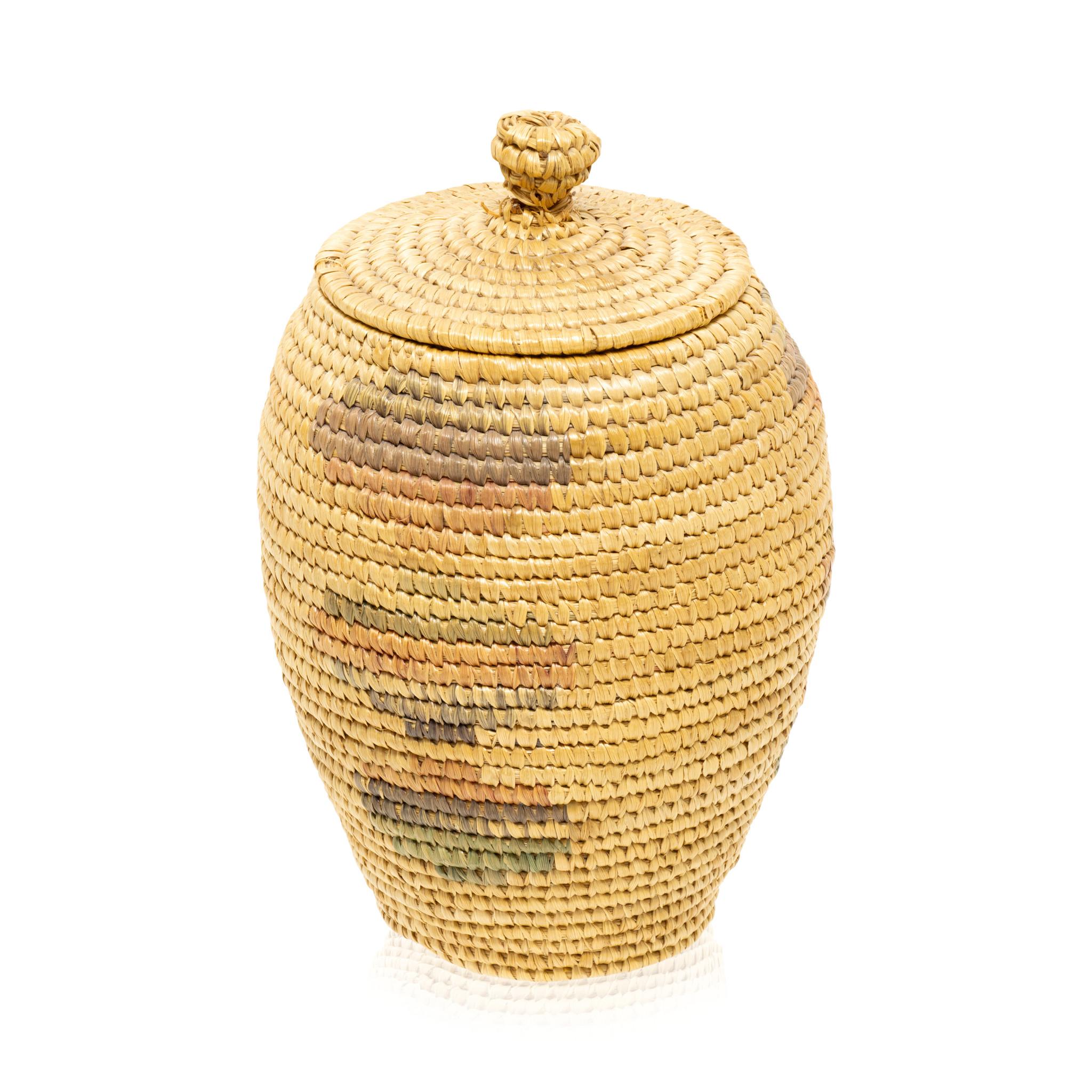Cesta esquimal de Alaska con tapa y nudo superior de tejido muy fino. Cónico desde abajo. Con diseños geométricos de colores semidesteñidos en el cuerpo. Ideal para exponer o para un uso continuado y cuidadoso. Pieza de mediados del siglo XIX.