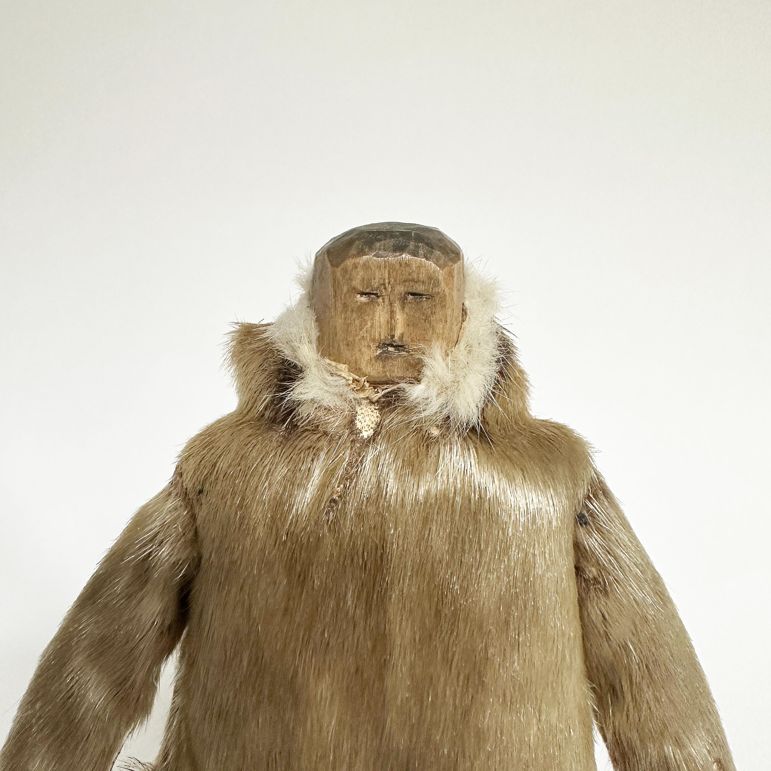 Tribal Eskimo Wood Carving of a Man with Seal Coat, North Coast, 20th Century For Sale