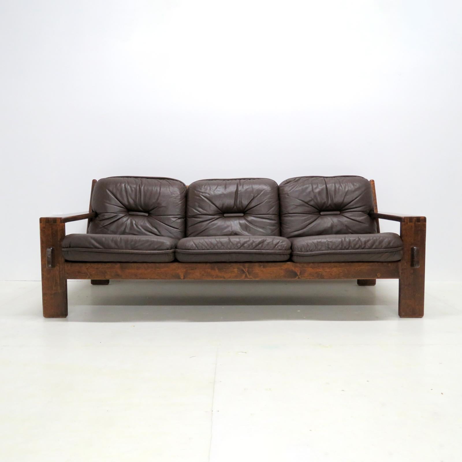 Bold, oversized three-seater sofa 'Bonanza' by Esko Pajamies for Asko, Finland, 1970, with thick dark brown, tufted leather on a dark stained wood frame, marked.