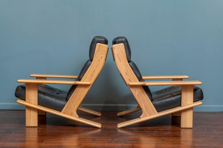 Esko Pajamies design Pele lounge chairs, Finland. Massive scale lounge chairs with impressive comfort, combining a stripped down simple yet modern frame made out of lacquered pine with black leather cushions. Rare form design embracing the 1970's