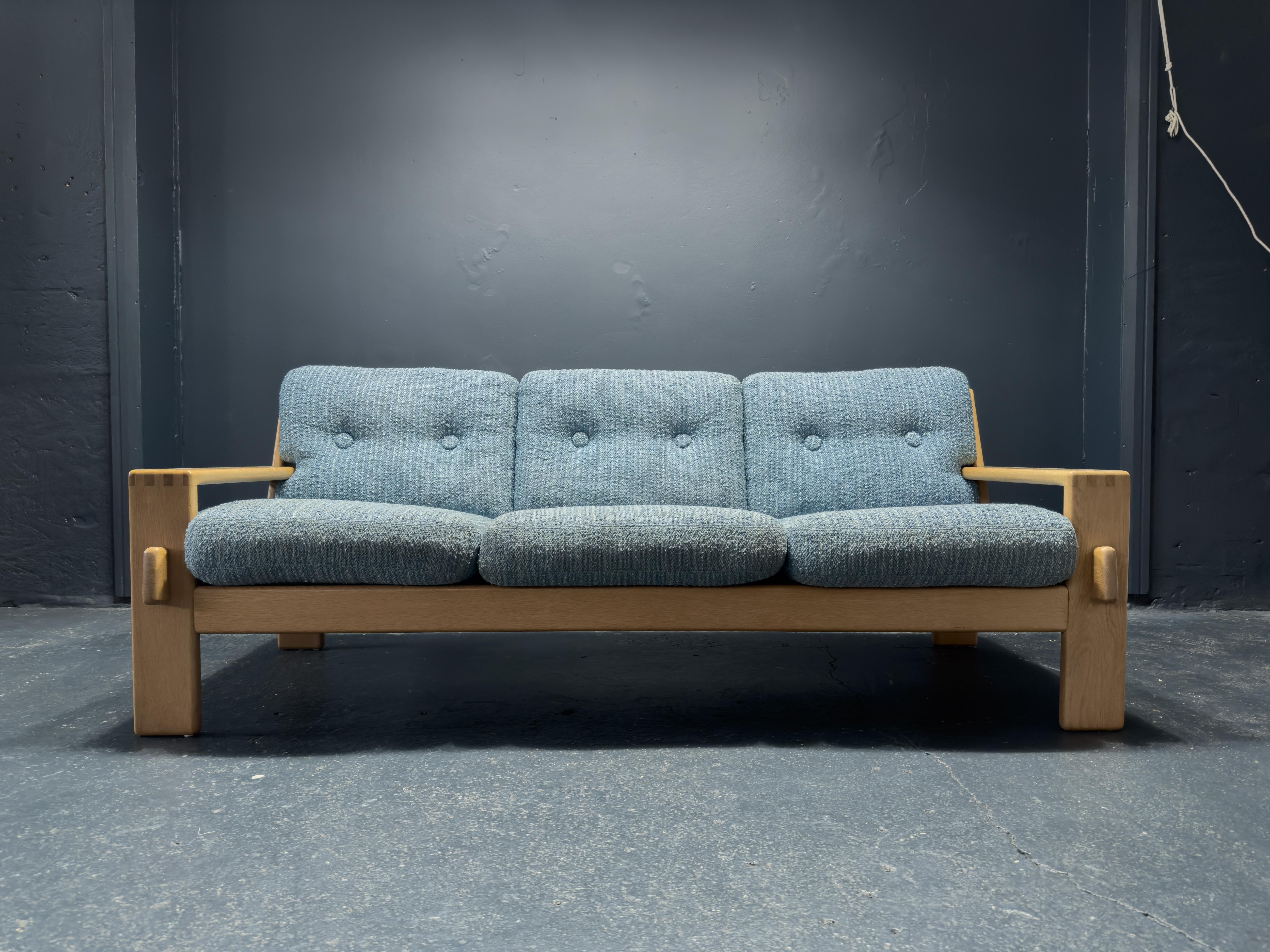 This unique three seater sofa titled the 'Bonanza' sofa was part of the Bonanza furniture series created by Finnish designer Esko Pajamies in the 1960s for furniture manufacturer Asko. 

This incredible piece features a strong angled oak frame, it