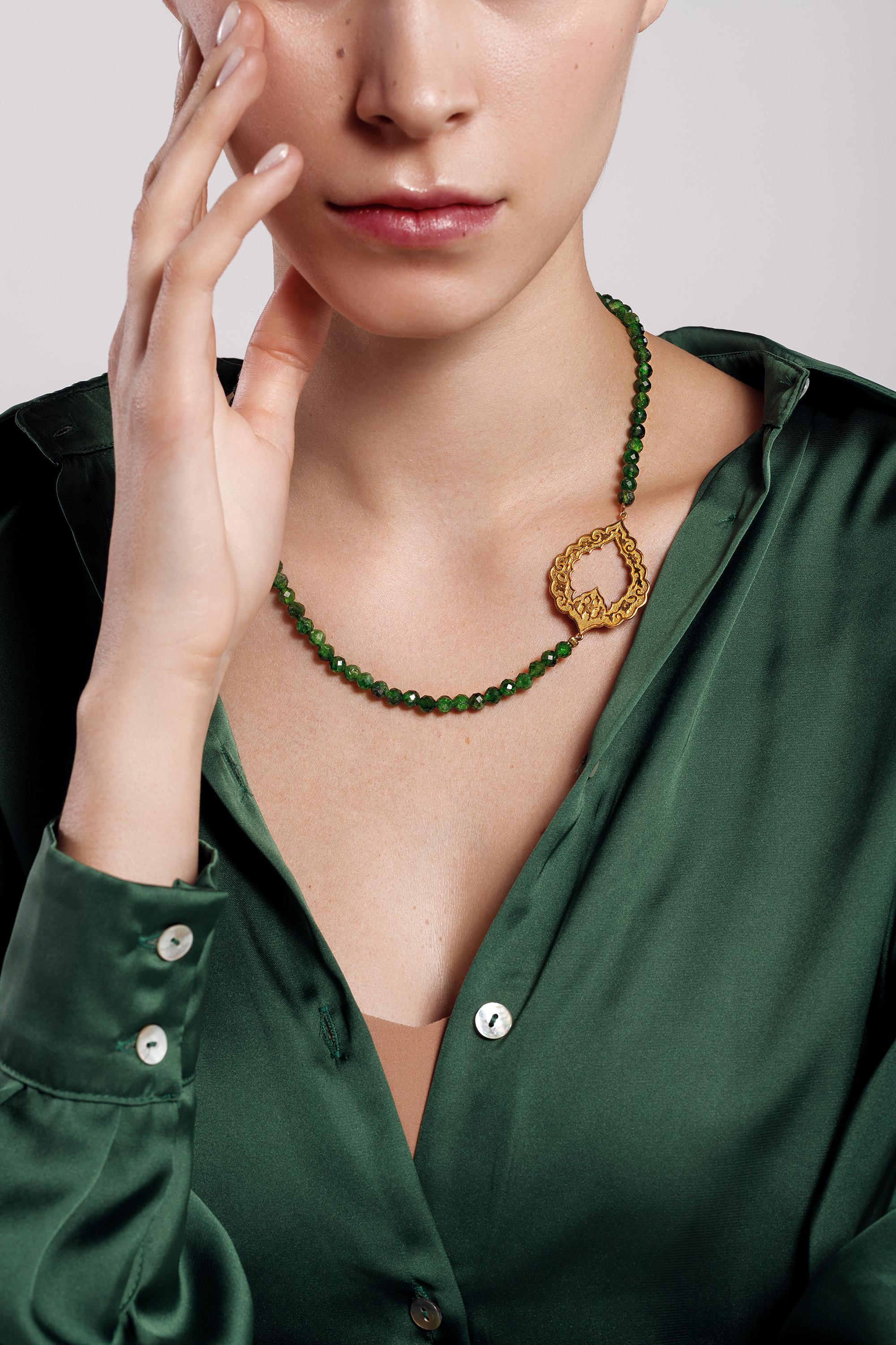 The Eslimi necklace in 18K yellow gold and natural diopside was inspired by patterns and shapes in Persian architecture. This statement necklace with its bold, timeless, contemporary and elegant design, pays homage to Sanaz Doost's motherland Iran,