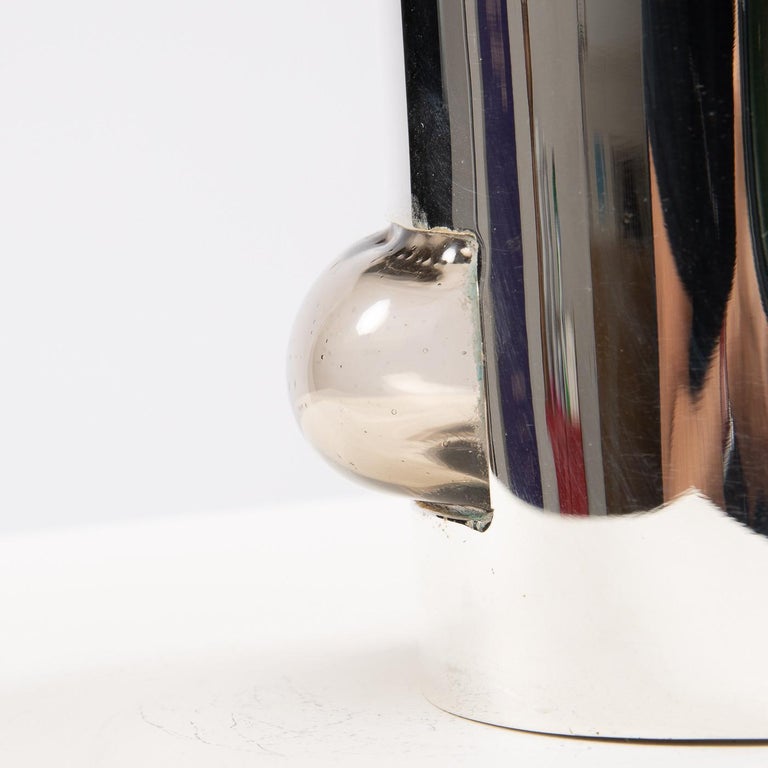 Vase consisting of a silvered metal envelope in which an expansion of smoked glass has been blown. The blown glass 