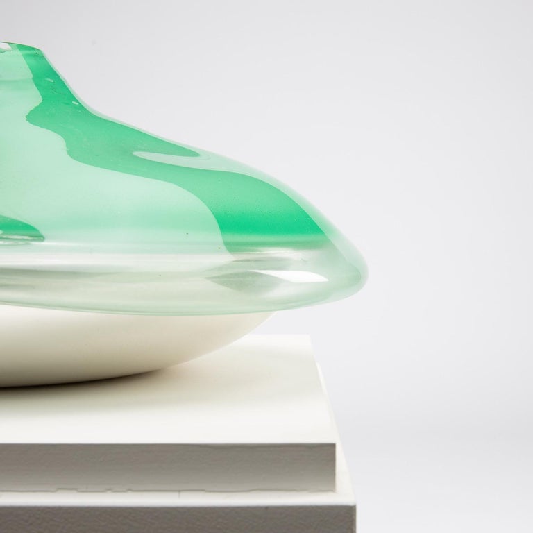 Vase consisting of a base in the form of a large saucer in silvered metal
in which a very clear green glass expansion has been blown.

The blown glass constituting a free form in the shape of a volcano 