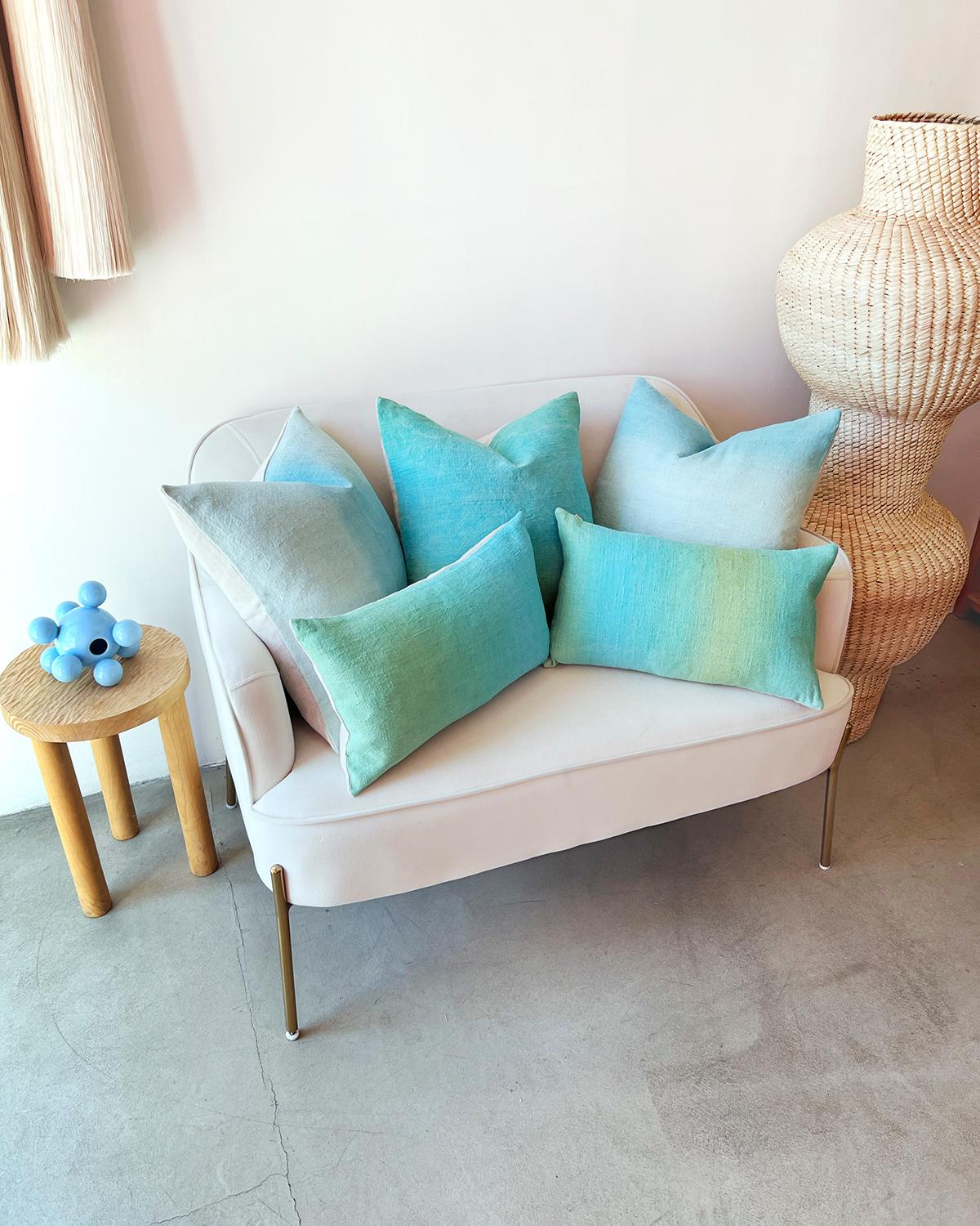These handmade aqua blue and sky blue ombre cushions are the perfect pop of color to brighten up your space. Hand made from natural materials like vintage linen, they are sure to make your living room or bedroom feel more modern while adding a