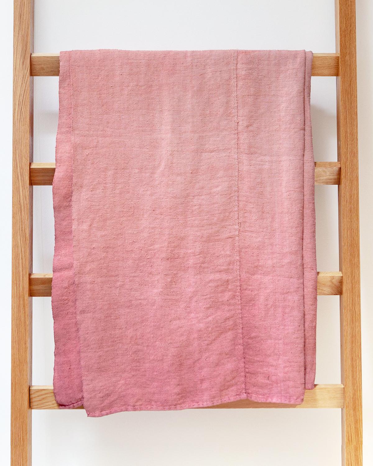 Un jeté ombré rose discret pour votre chambre à coucher. Ce jeté de lin vintage est peint à la main dans une belle teinte rose avec des détails rustiques en détresse, créant une atmosphère subtile mais douillette. Parfait pour la chambre à coucher,