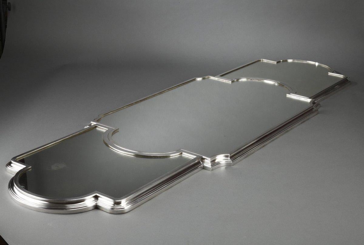 Spécialement pour une table en trois parties de forme demi-lune avec un fond de miroirs, montée sur un parquet en chêne, lingotière en métal argenté à double évolution. Petit manque dans le teint du miroir. Il est présenté dans un coffre en chêne