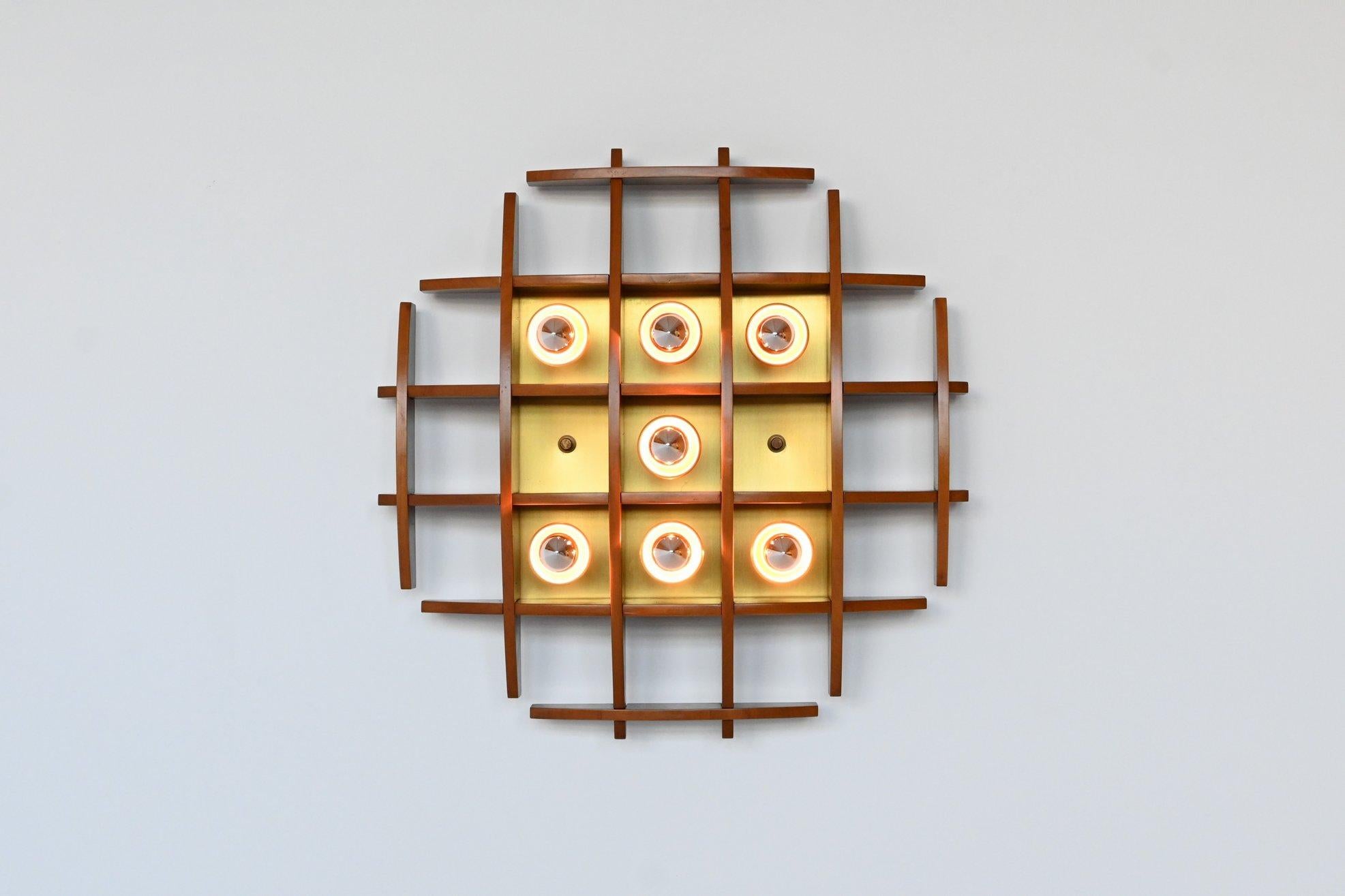 Impressive wall or ceiling lamp manufactured by Esperia, Italy 1970. This lamp is made of teak wood and has brass details like the fittings and wall plate. It can be used as wall or ceiling lamp. Beautiful geometric lamp in very good condition and