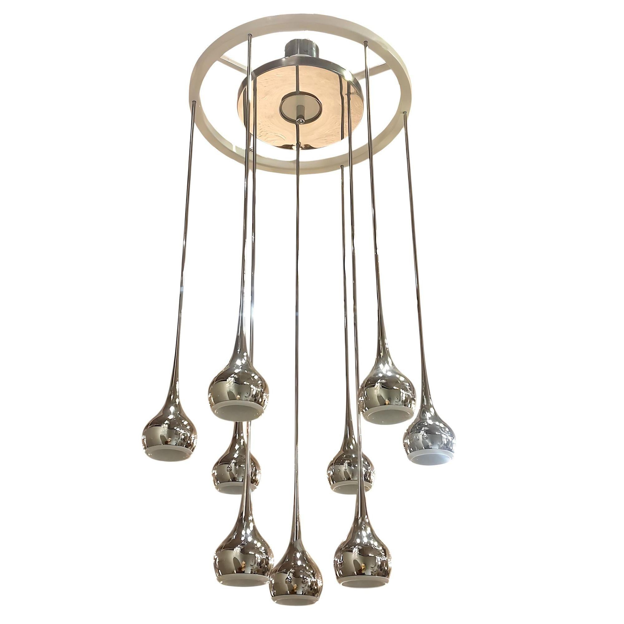 Lámpara colgante o empotrable cromada de la Modernidad de Mitad de Siglo, firmada por Esperia, Italia años 70.
La araña vintage está formada por nueve colgantes cromados estriados.
Cada luz acanalada cromada tiene un centro de cerámica blanca, en el