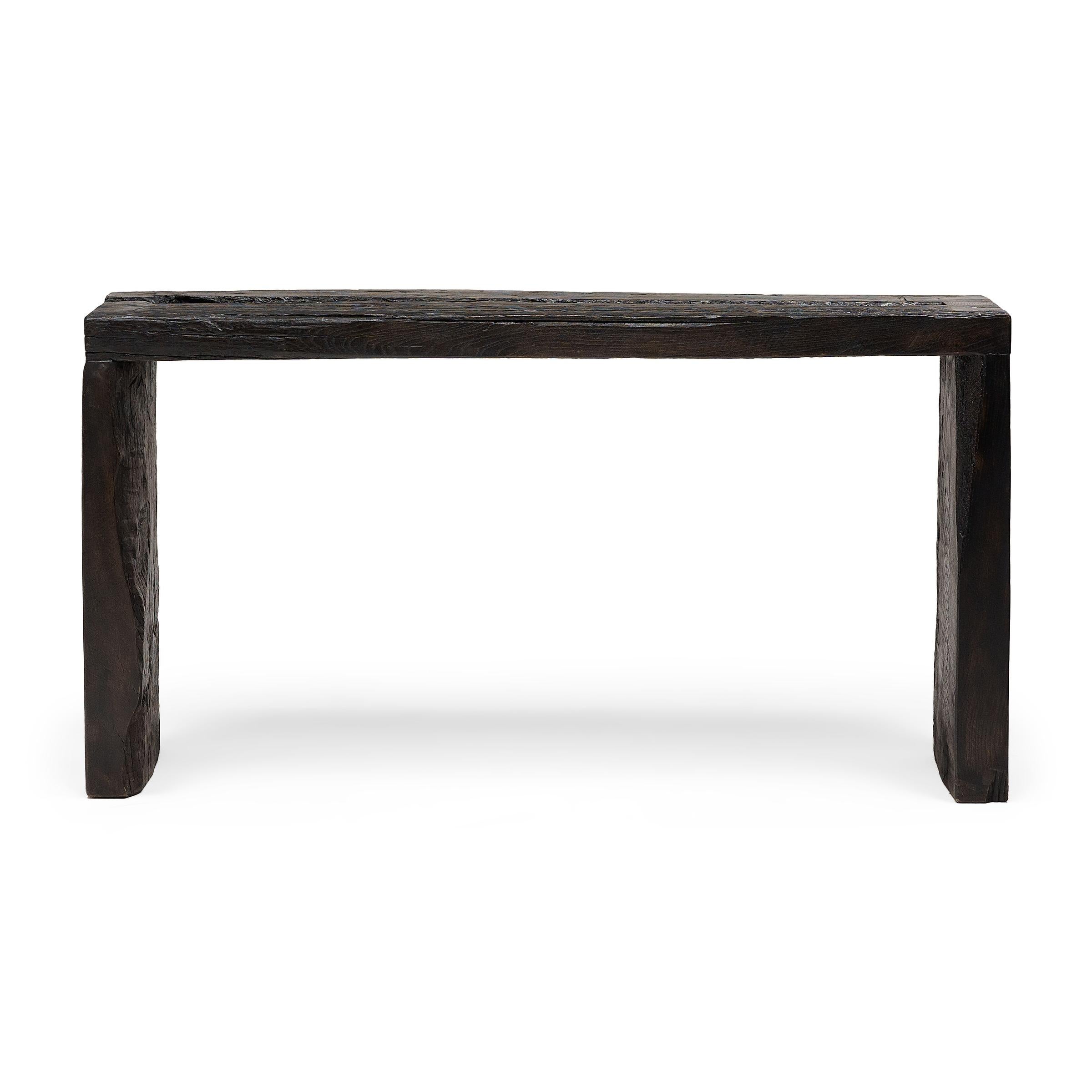 This modern console table is a celebration of wabi-sabi style. Crafted of wood reclaimed from Qing-dynasty architecture, the table has a minimalist waterfall design with dovetailed corners that recreate traditional joinery methods and add intrigue