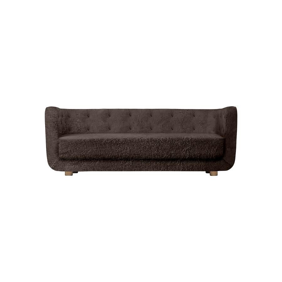 Espresso sheepskin and smoked oak Vilhelm sofa by Lassen
Dimensions: W 217 x D 88 x H 80 cm 
Materials: sheepskin, oak.

Vilhelm is a beautiful padded three-seater sofa designed by Flemming Lassen in 1935. A sofa must be able to function in