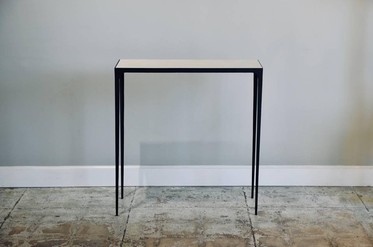 Understated 'Esquisse' wrought iron and parchment console by Design Frères. Chic parchment top fitted onto a slender matte black wrought iron base.