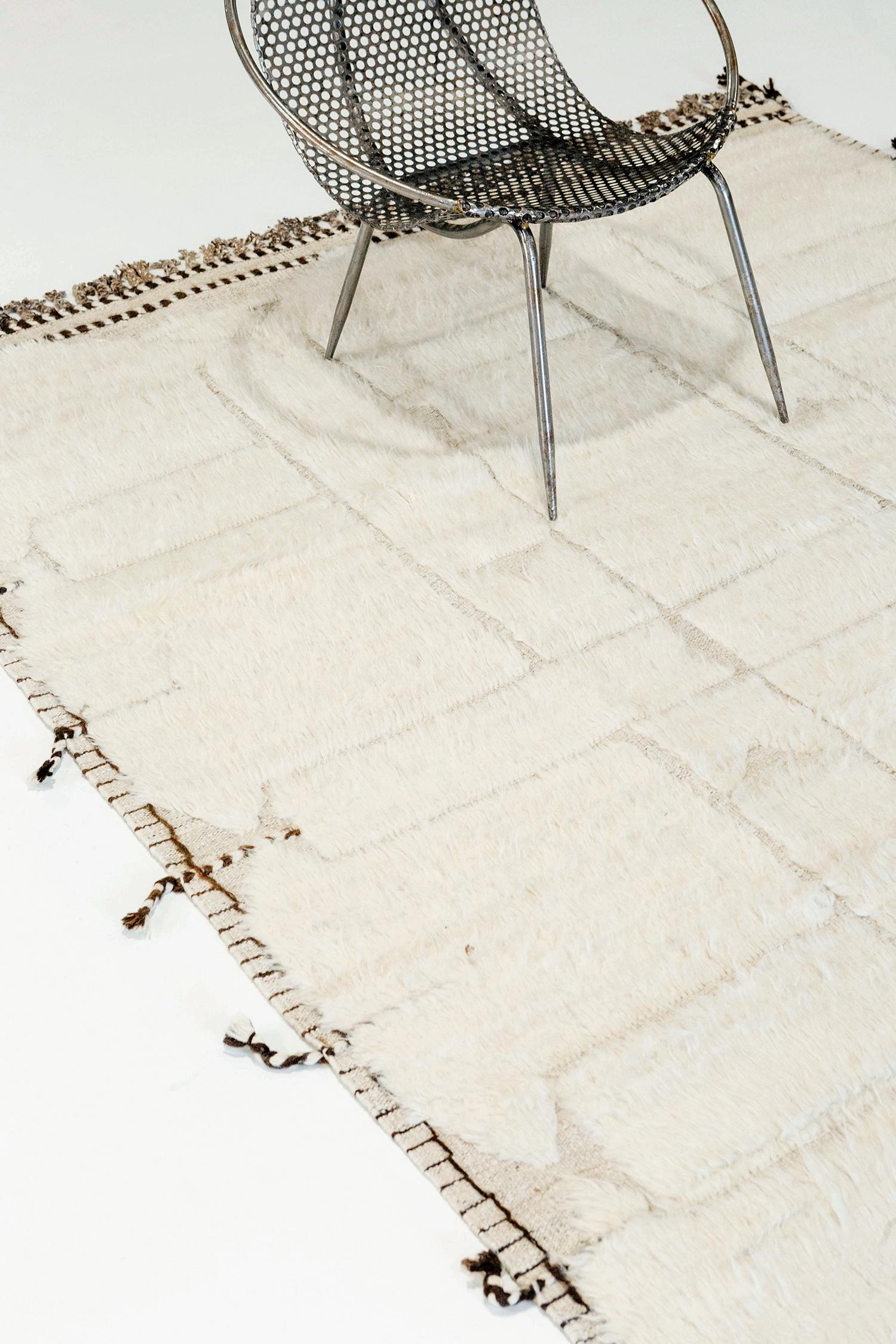 Essaouina' is a beautifully textured rug with embossed designs inspired from the Atlas Mountains of Morocco. Surrounded by ivory shag and tasseled borders, Essaouina makes for a great contemporary interpretation for the modern design world.