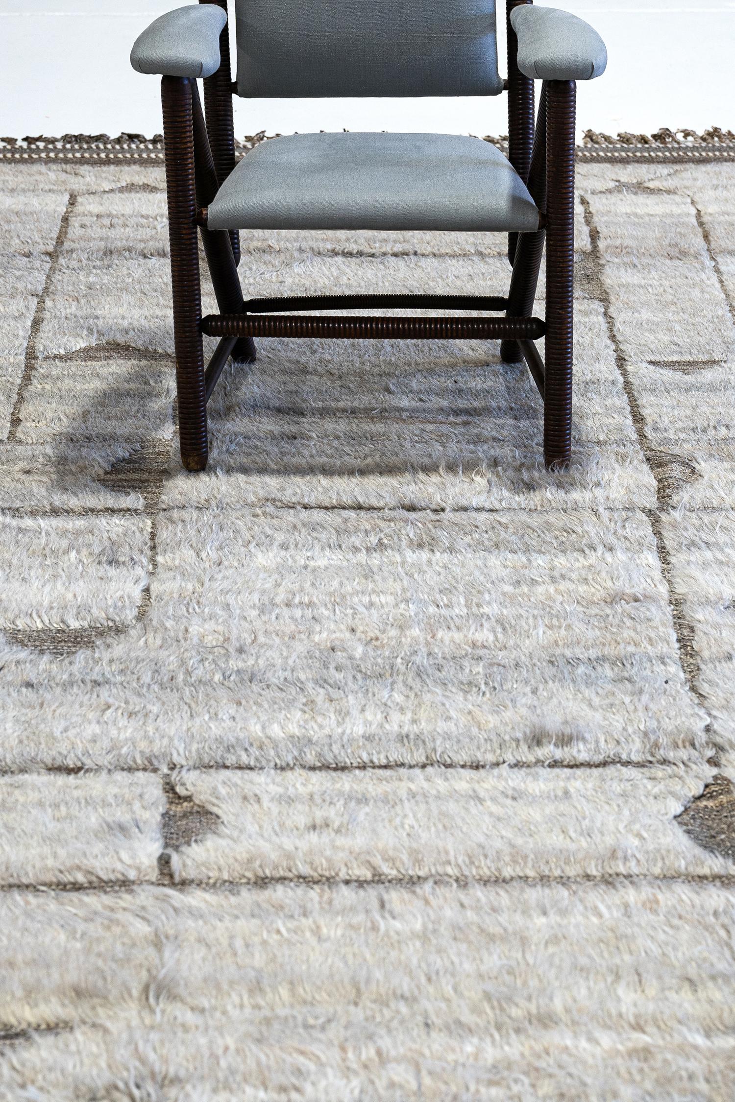 Essaouina' is a beautifully textured rug with embossed designs inspired from the Atlas Mountains of Morocco. Neutral brown motifs surrounded by a natural shag and tasseled borders make for a great contemporary interpretation for the modern design