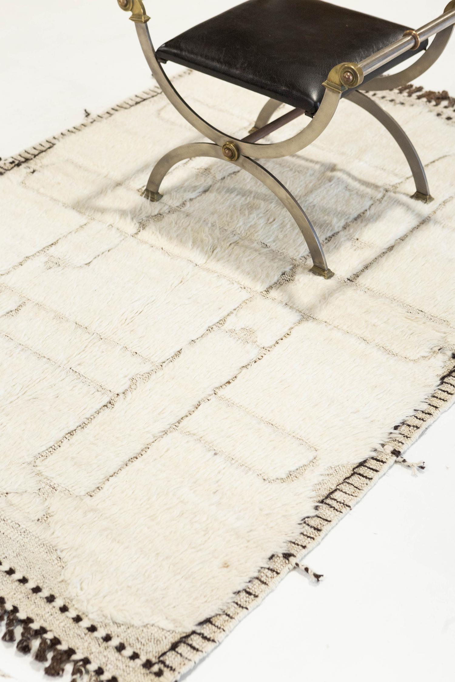 'Essaouina' is a beautifully textured rug with embossed designs inspired from the Atlas Mountains of Morocco. Natural colored motifs surrounded by ivory shag and tasseled borders make for a great contemporary interpretation for the modern design