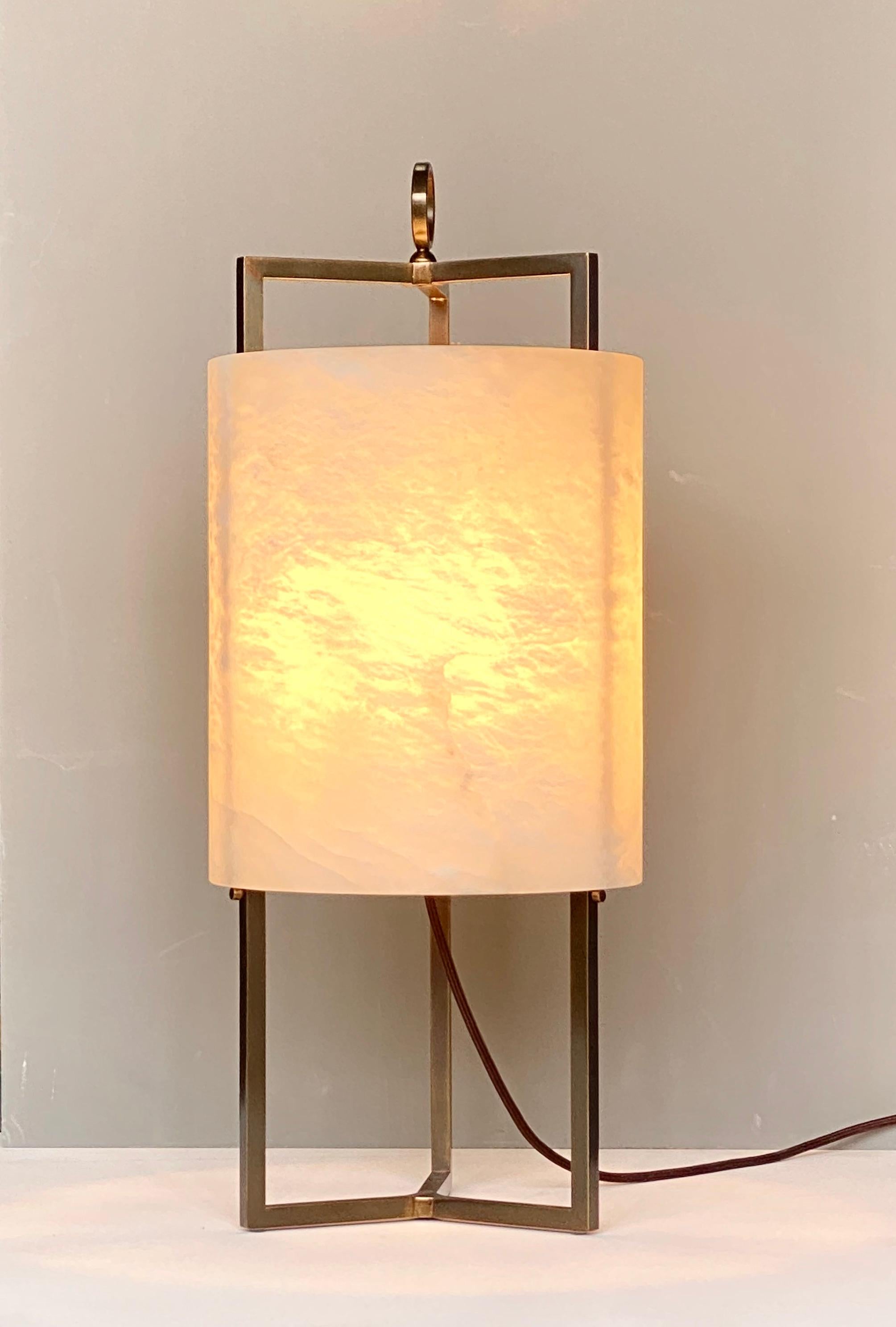 The reinterpretation of the classic lantern that you describe is a beautiful and unique design. The use of a three-stemmed brass structure to support the cylindrical lampshade made from a solid alabaster block creates an interesting contrast between
