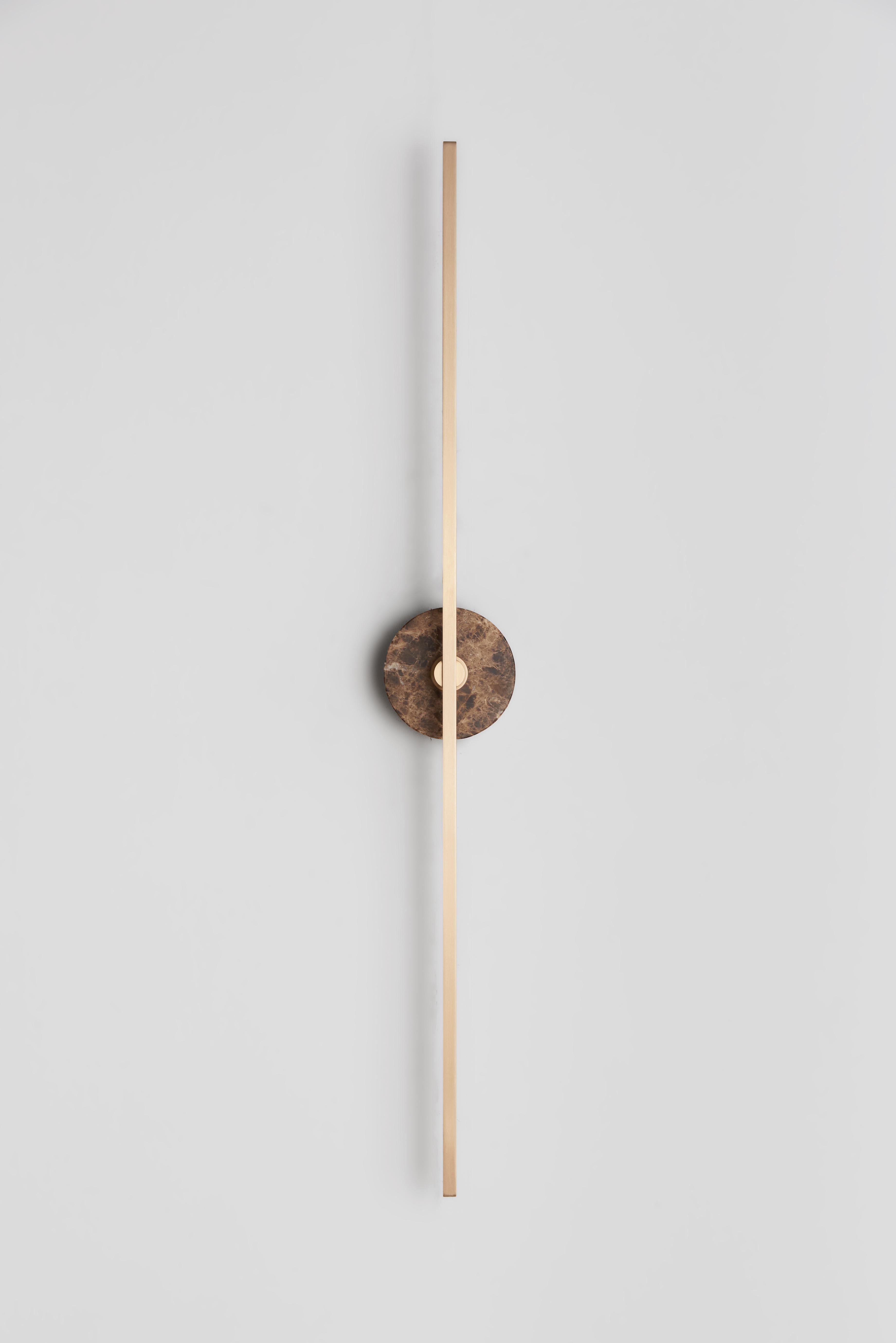 The Stick wall sconce is a contemporary lighting fixture that features a minimalist design with thin brass profiles and advanced LED technology. It emits a warm and diffused light that adds a cozy and inviting atmosphere to any room.

The Brown