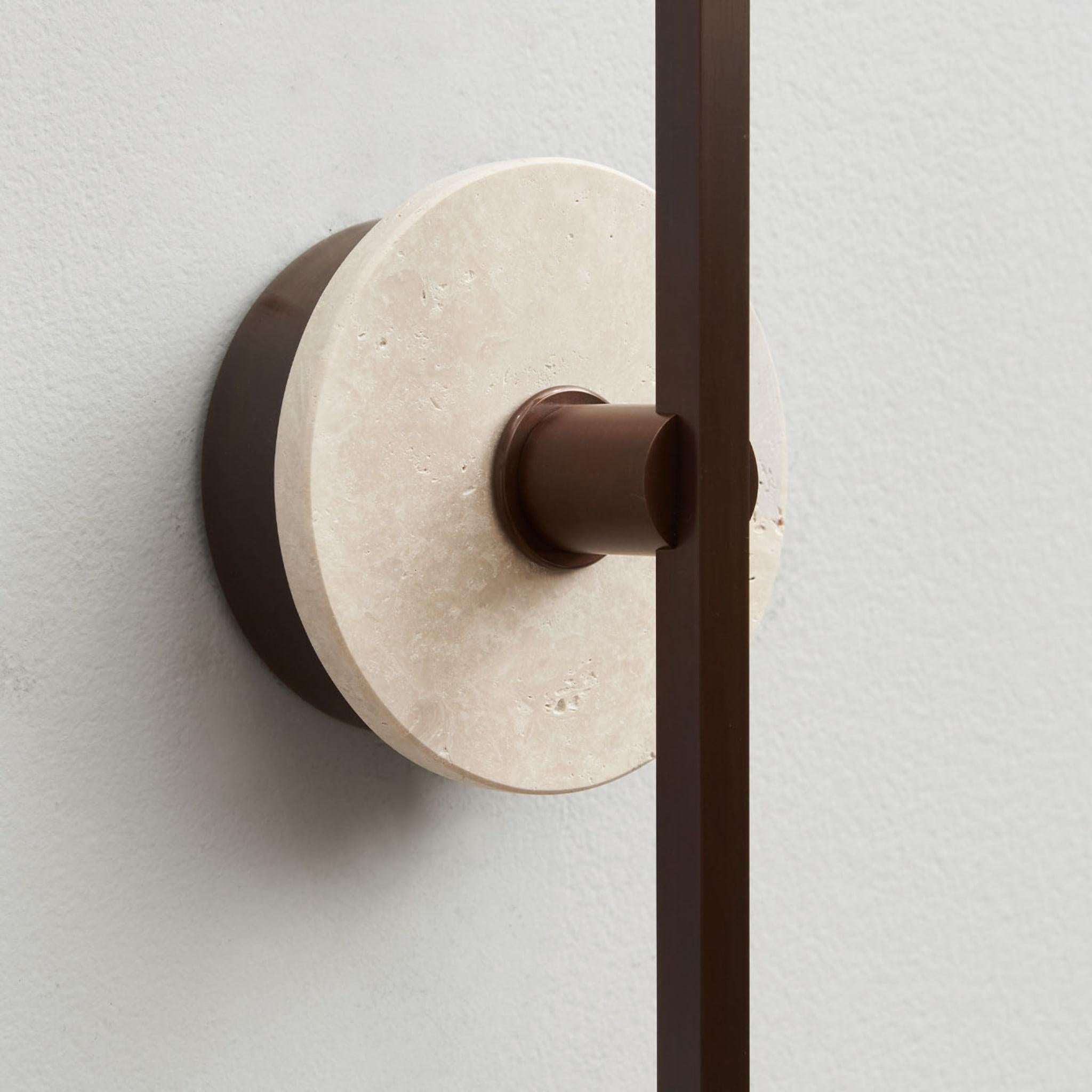 The Stick wall sconce combines the minimalism of thin bronze profiles with the functionality and power of led technology, offering a warm and diffused light. The travertine, a purely decorative element, embellishes the product's structure with a