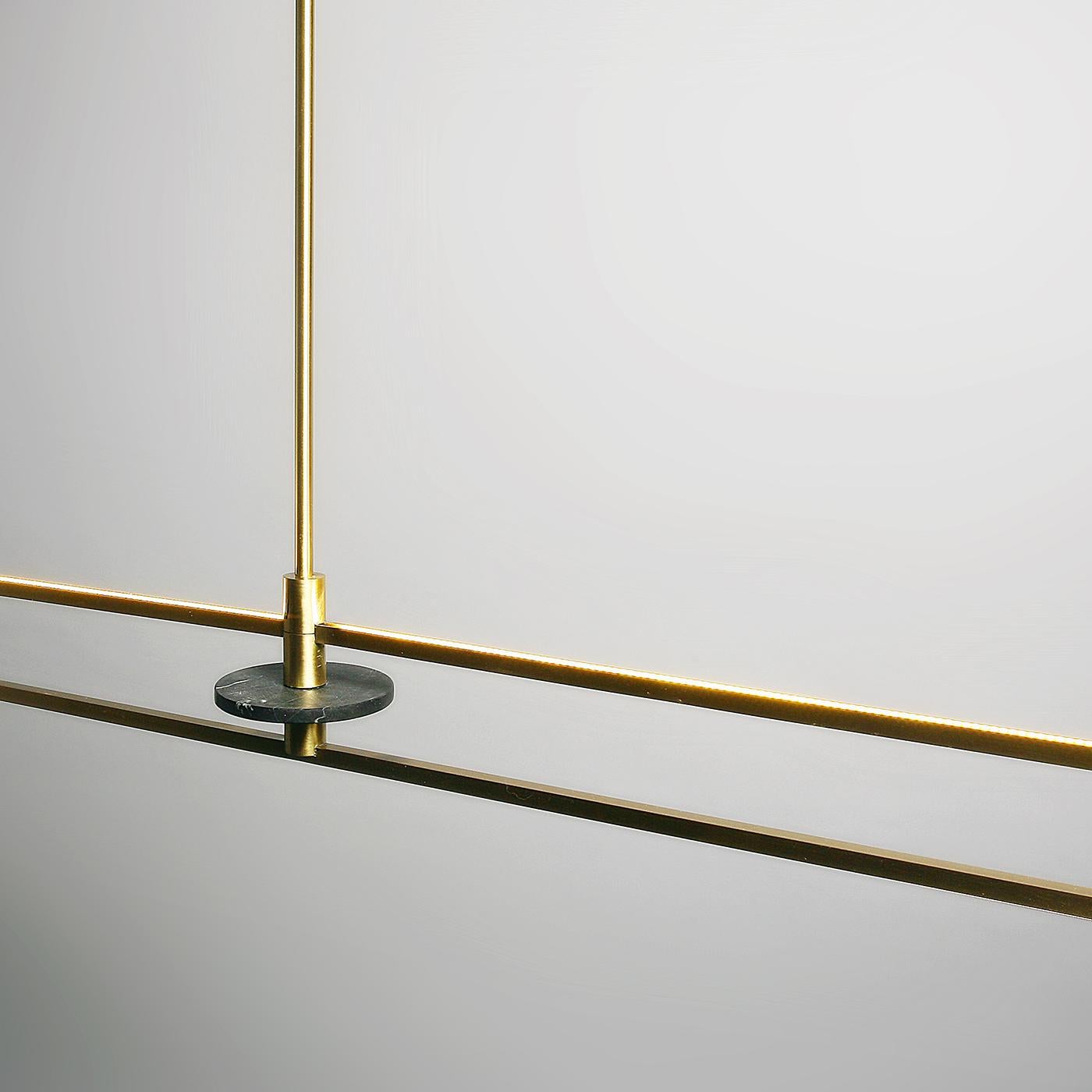 Minimalismo e funzionalità contraddistinguono quest'opera d'arte scultorea alimentata dalla tecnologia LED. La luce calda e diffusa di questa lampada è racchiusa in un lineare ottone satinato con un accento decorativo in marmo nero Marquina. Le