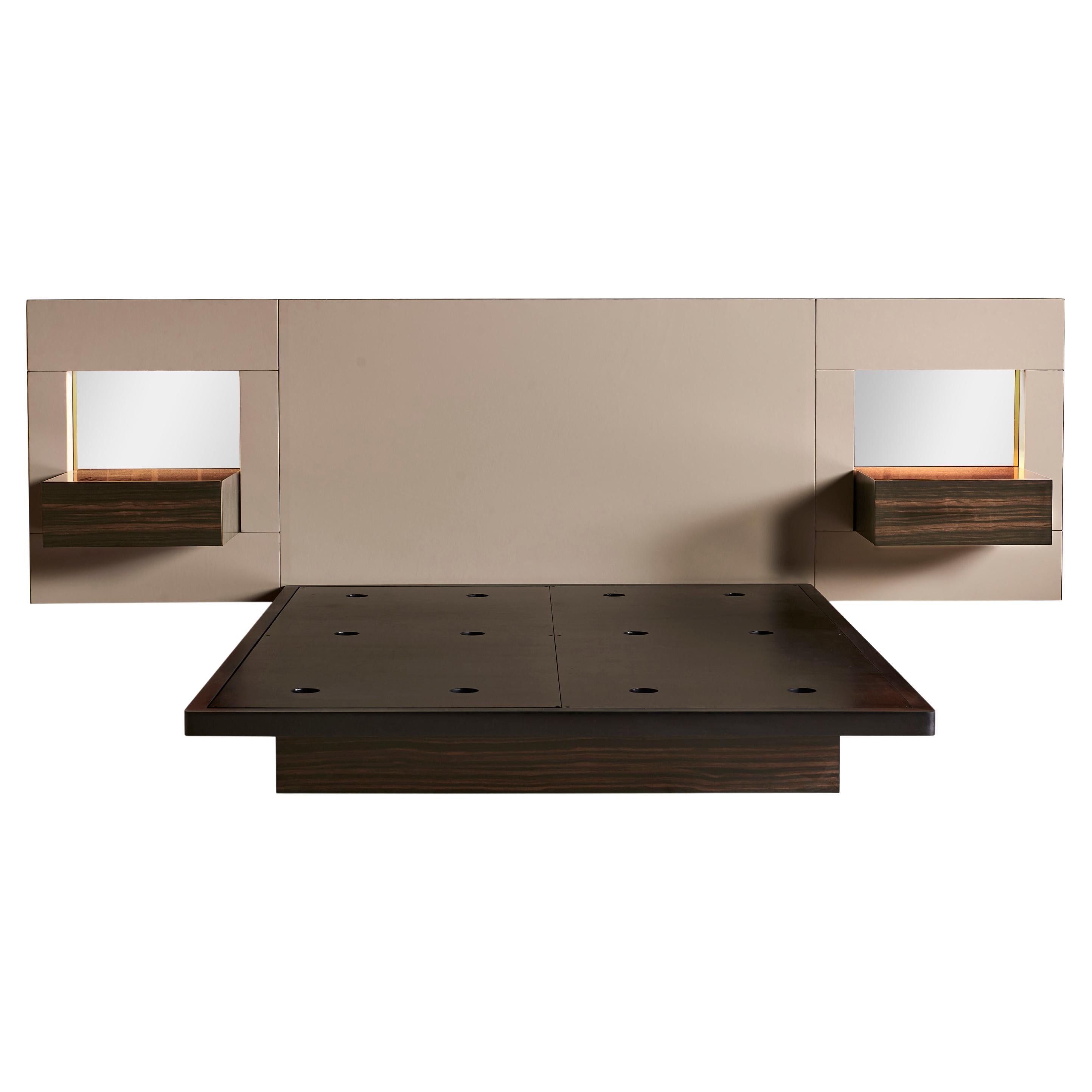 Sleek and contemporary, the Essex Bed is constructed of a wooden frame with a leather headboard wrapped in metal banding. Convenient wooden nightstands with concealed drawers are recessed within a mirrored cavity on each side of the headboard which