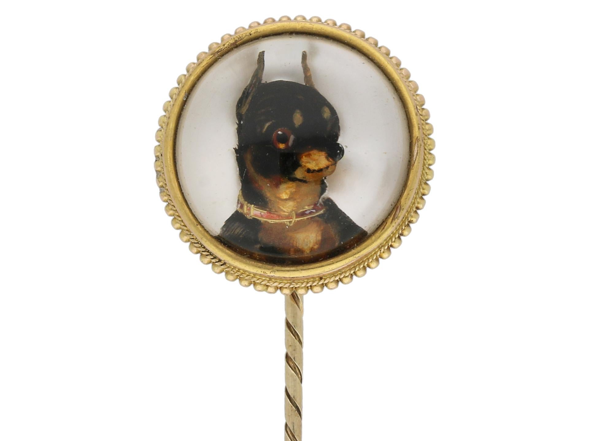 Essex crystal chihuahua pin. A yellow gold pin, set with a hand painted and carved Essex crystal depicting a chihuahua, surrounded by a fine cannetille work gold border, the reverse in mother of pearl back, all on a secure pin with decorative spiral
